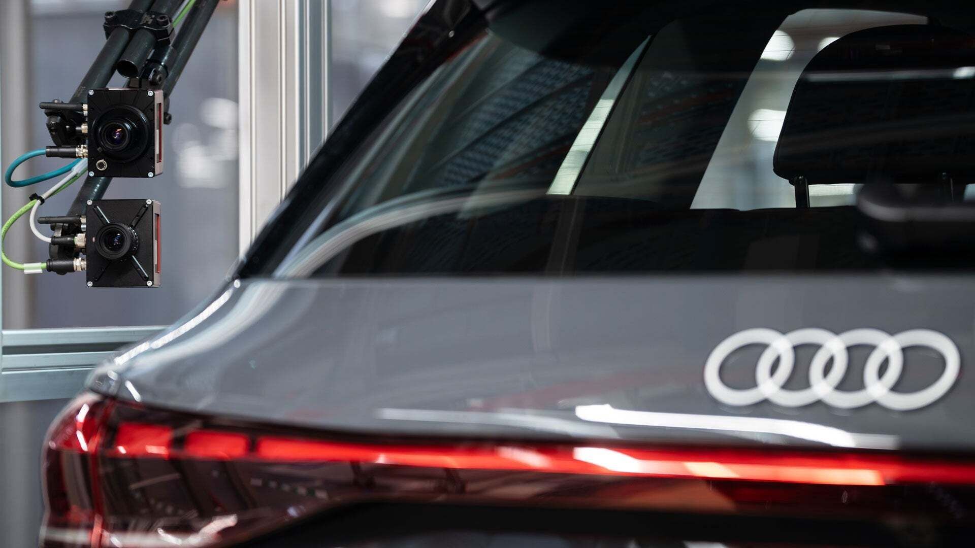Grauer Audi angeschlossen an externe Kameras und Sensoren in einer Produktionshalle