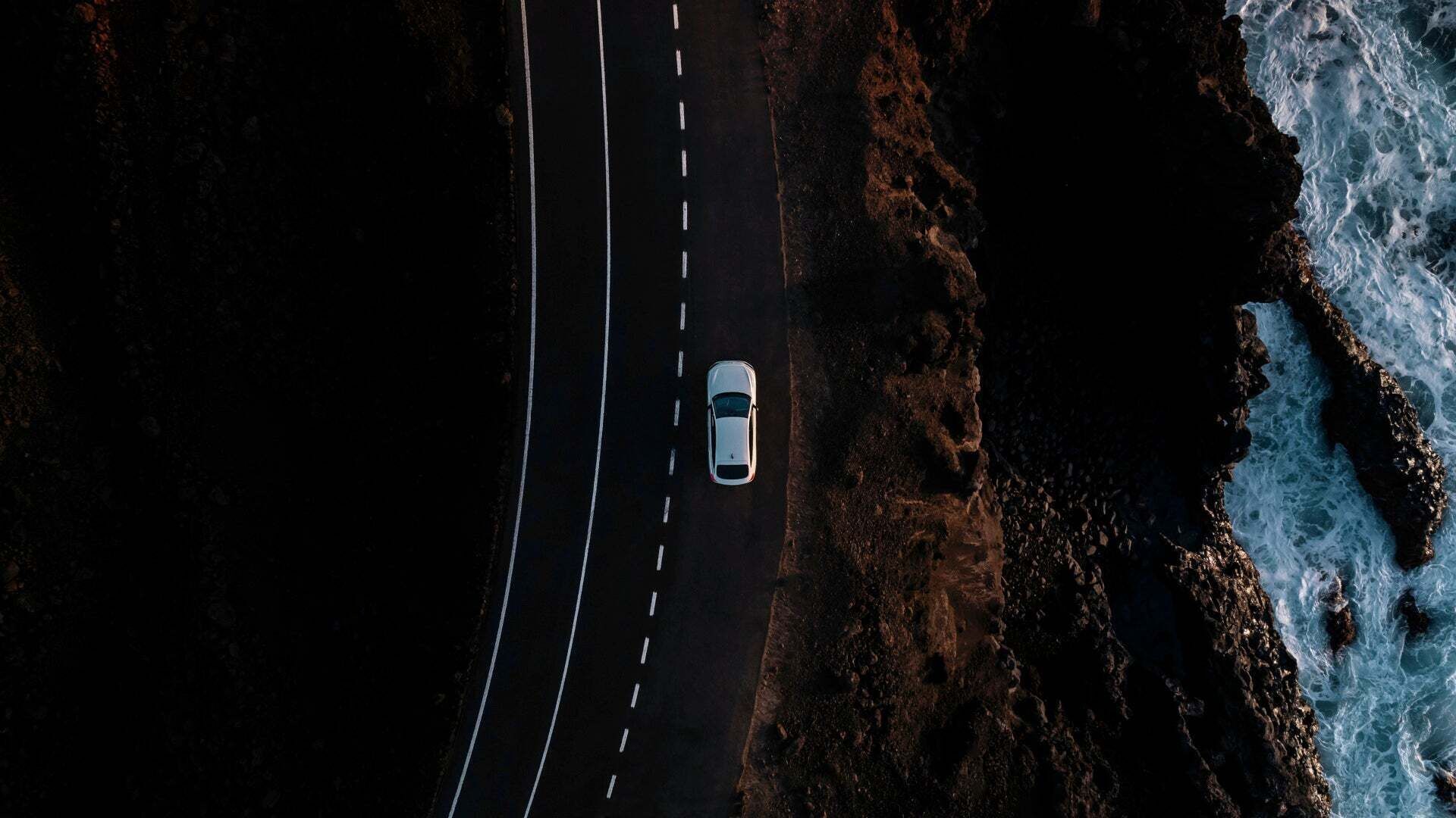 Audi A6 Sportback e-tron performance auf einer Landstraße am Wasser