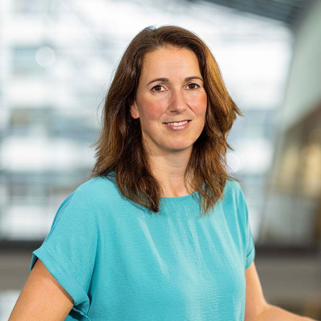 Meike Gallant trägt ein blauer Shirt und lächelt in die Kamera