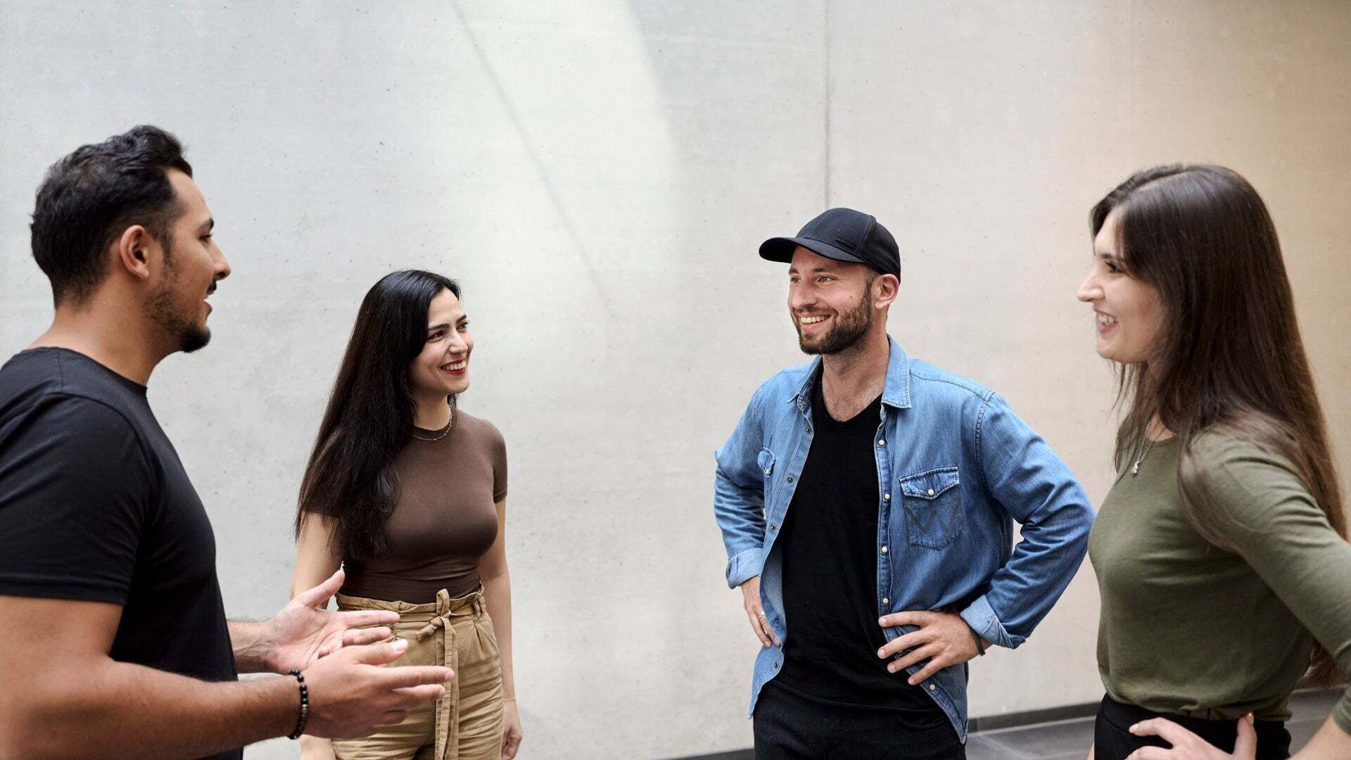 Vier Personen stehen im Kreis und sprechen in lockerer Atmosphäre miteinander.