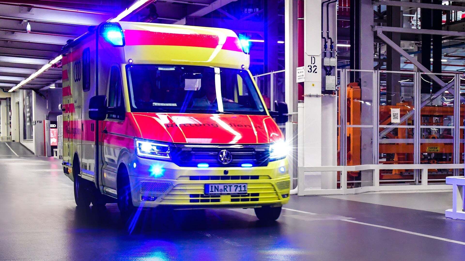 Ein Krankenwagen mit Blaulicht und der Aufschrift „Rettungsdienst“ fährt durch die Produktionsstraße.