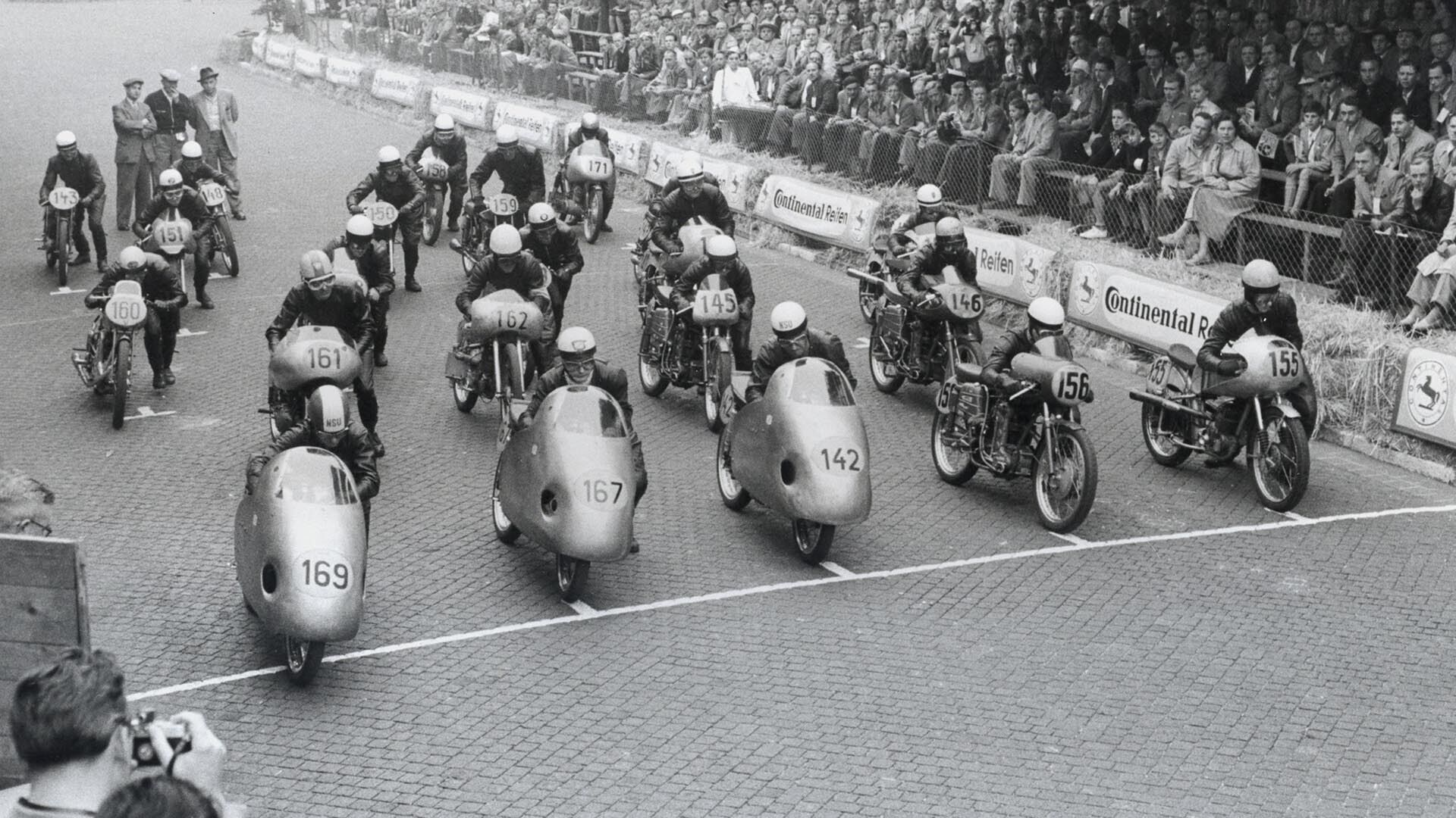 Das Foto zeigt den Start eines Motorrad-Rennens inklusive NSU-Motorrädern.