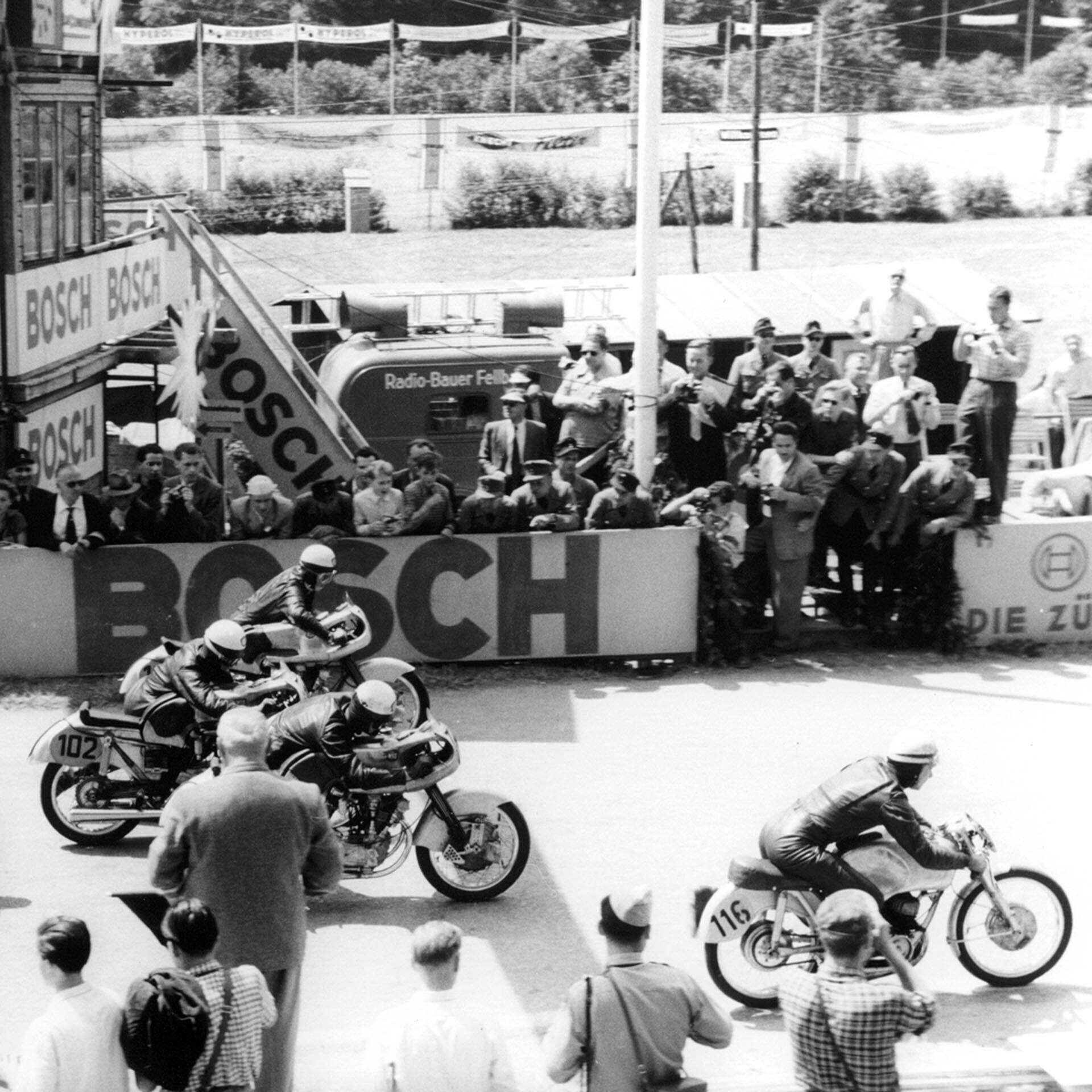 Das Foto zeigt den Start eines Motorrad-Rennens, inklusive NSU Motorrädern.