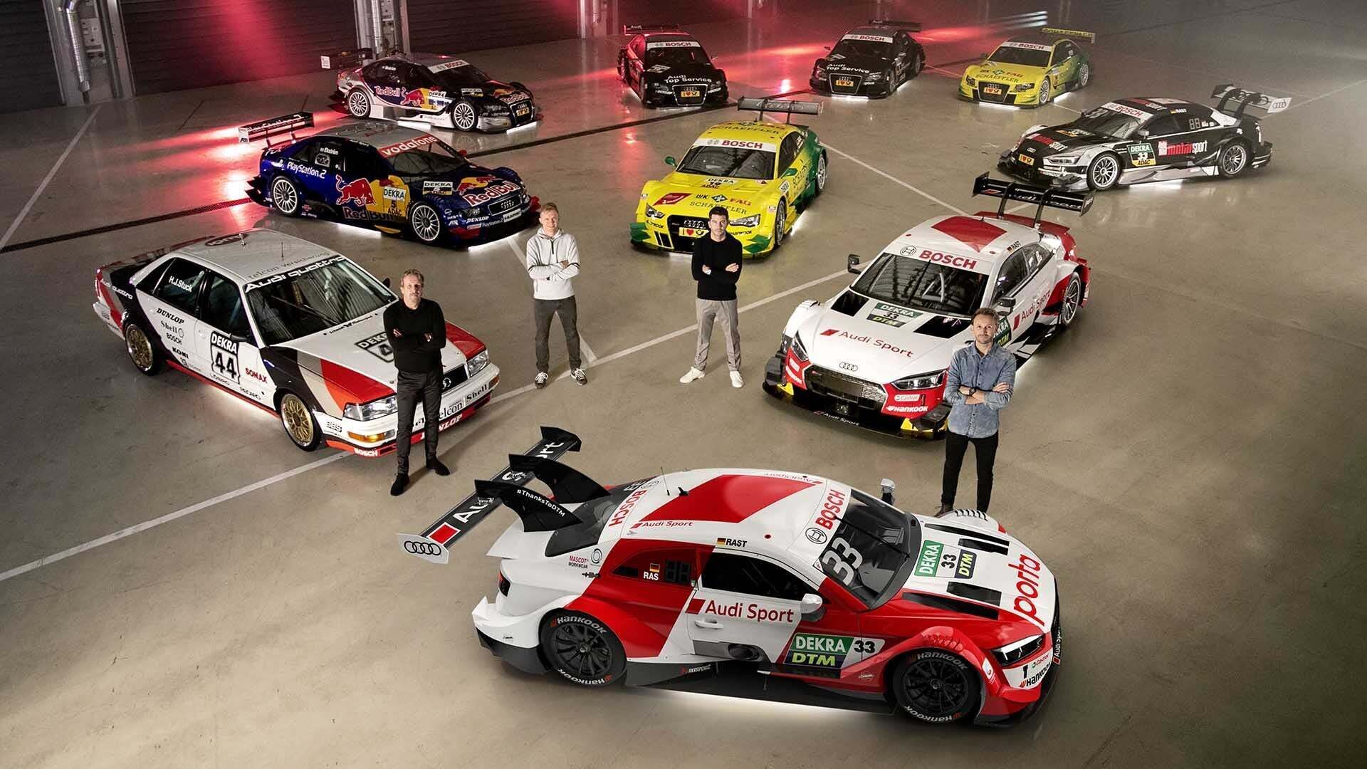 Gruppenfoto mit Audi Rennwagen und Fahrern, die DTM-Titel gewonnen haben, aufgenommen in Neuburg an der Donau.