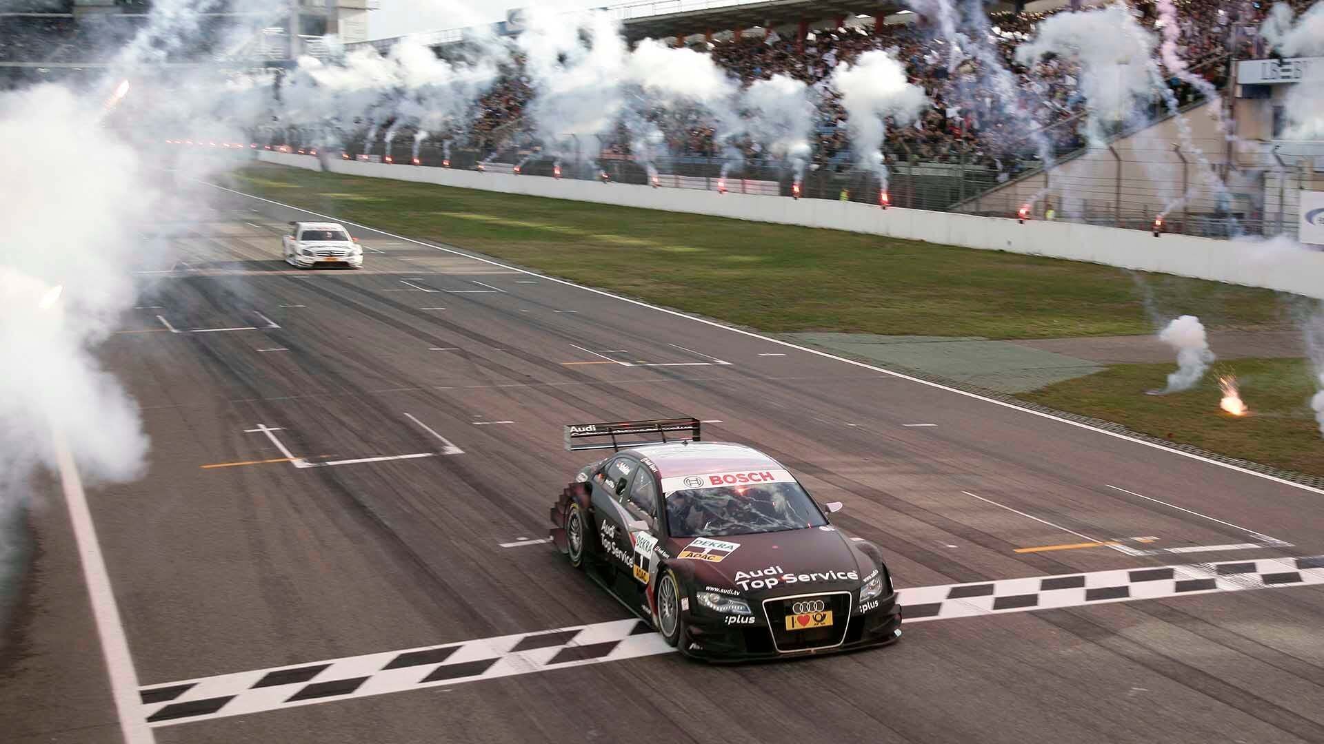 Das Foto zeigt Timo Scheiders Audi A4 DTM beim Überqueren der Ziellinie in Hockenheim 2009.