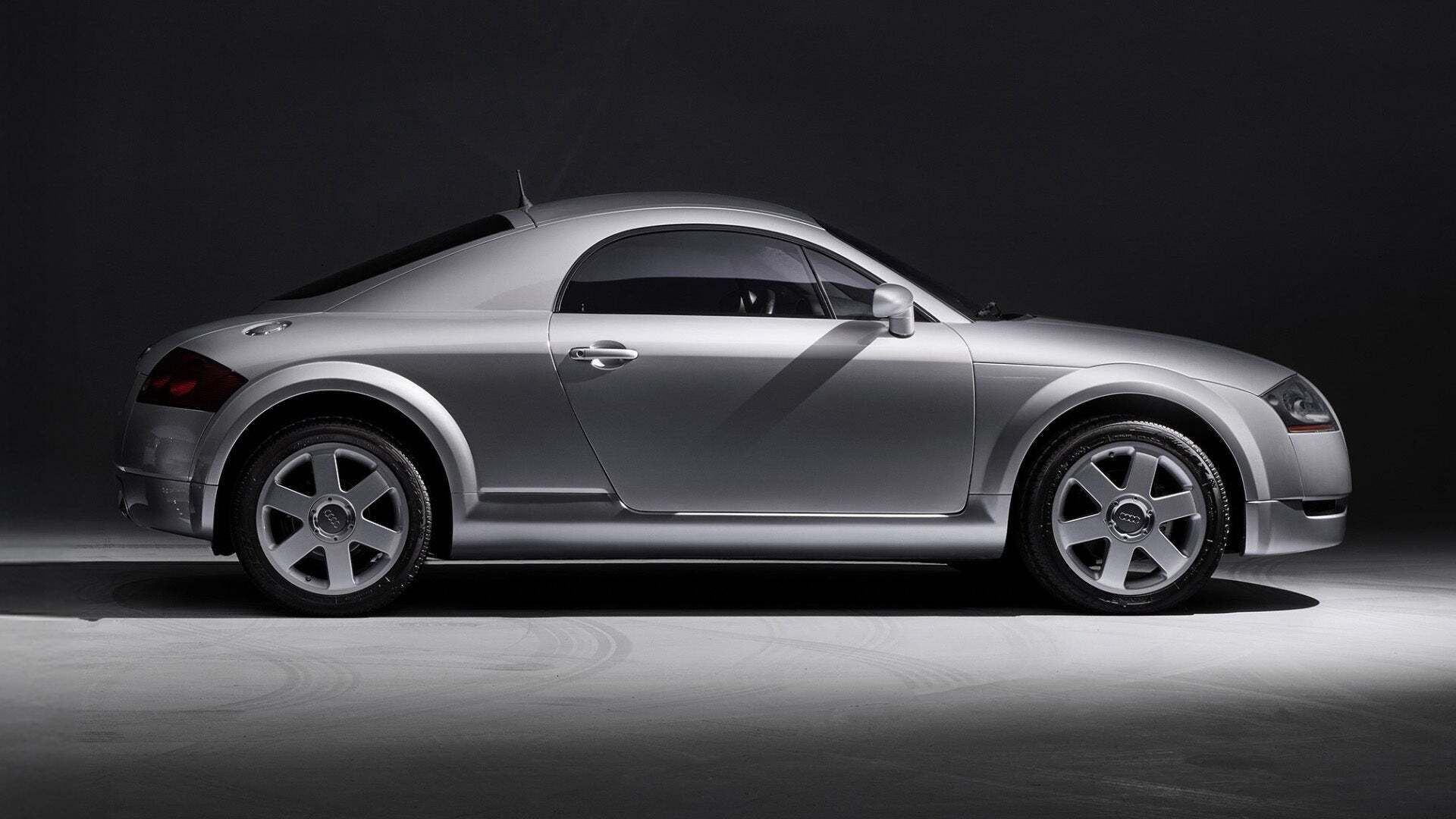 Seitenansicht eines Audi TT-Models vor grauem Hintergrund.