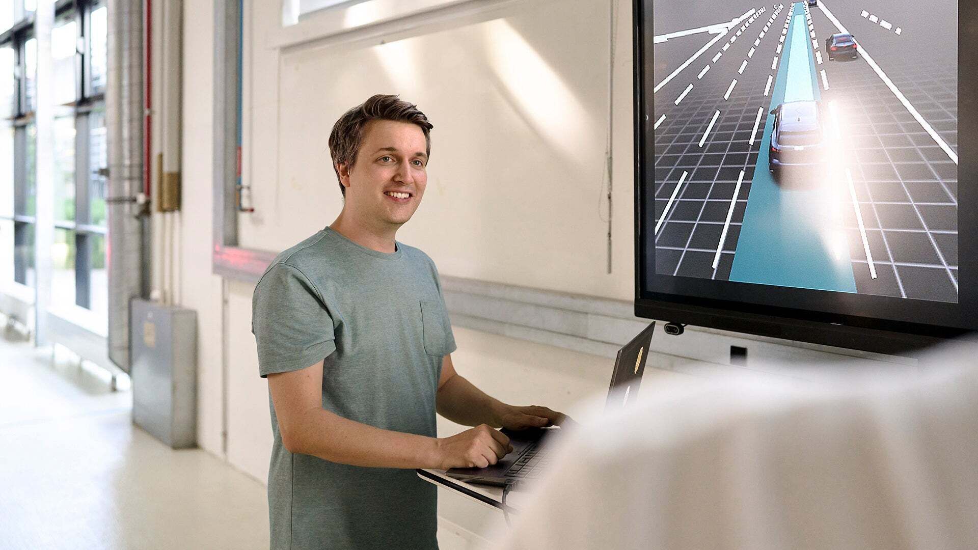 Jan Totz hat einen Laptop vor sich und schaut an der Kamera vorbei