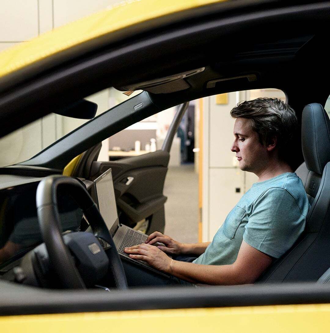 Jan Totz is sitting in the passenger seat of an Audi, looking at the laptop on his lap