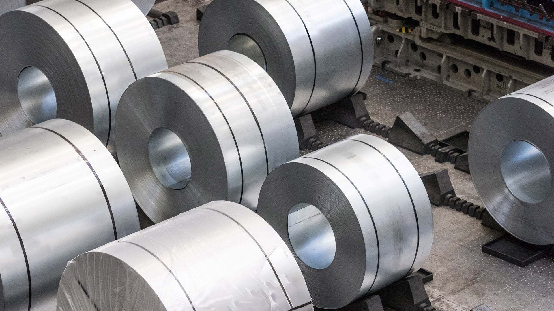 Mehrere große Metallcoils liegen im Presswerk am Audi-Standort Neckarsulm auf Halterungen nebeneinander.