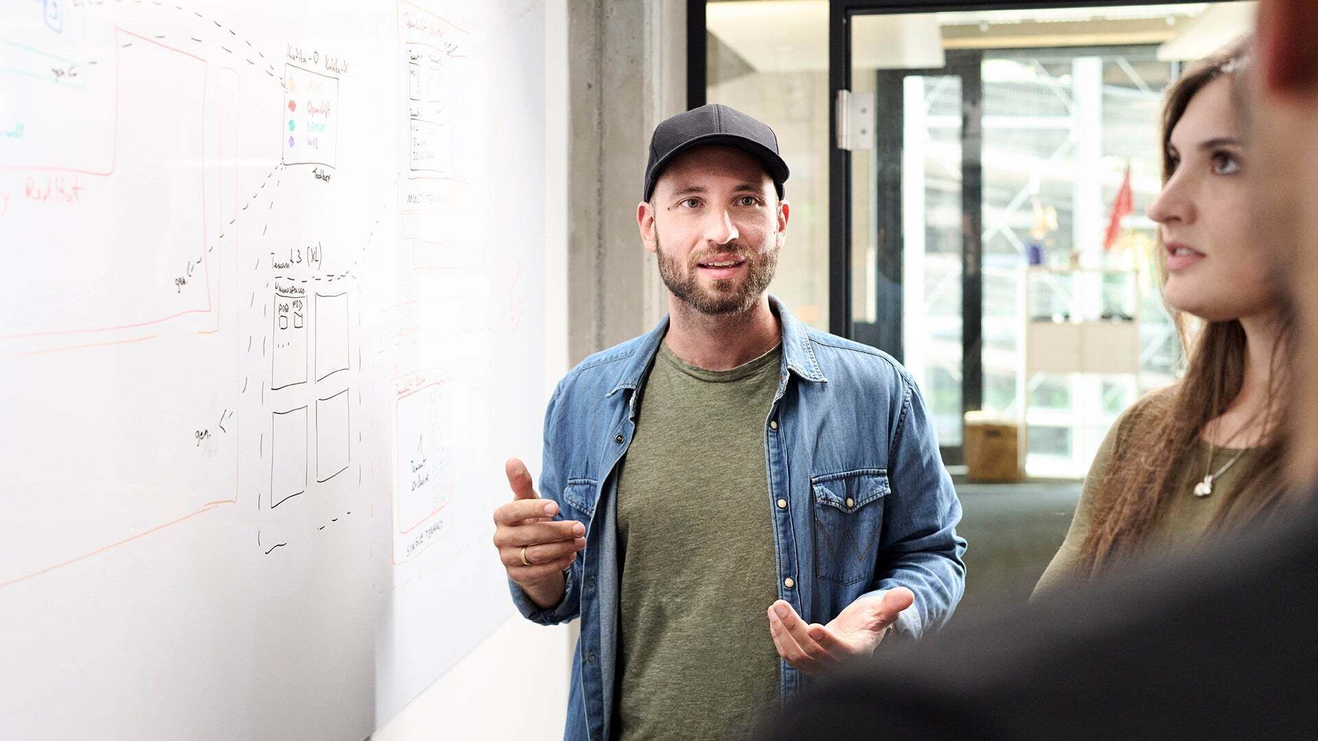 Sebastian Kister unterhält sich mit Kollegen und steht neben einem Sideboard mit Notizen darauf