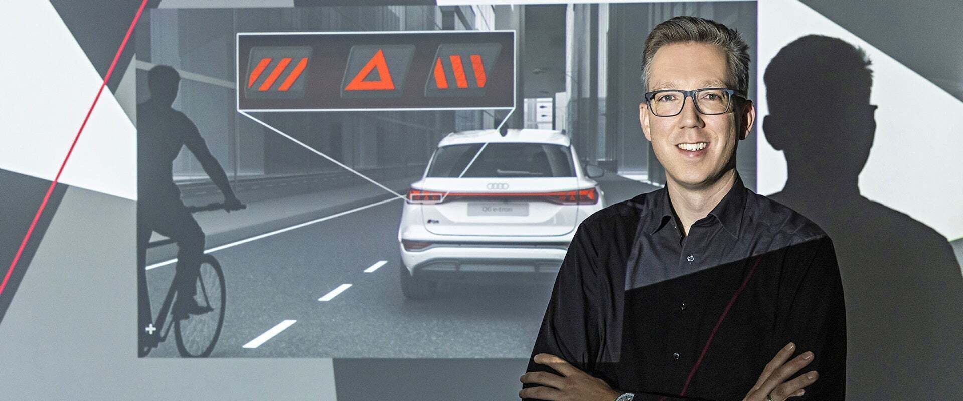 Portrait of Roland Kallweit next to a presentation on vehicle safety