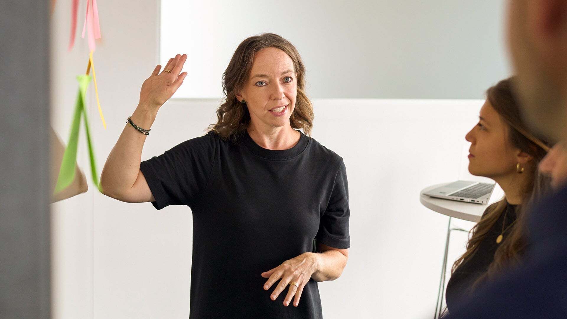 Melanie Limmer is in conversation with colleagues and raises her right hand
