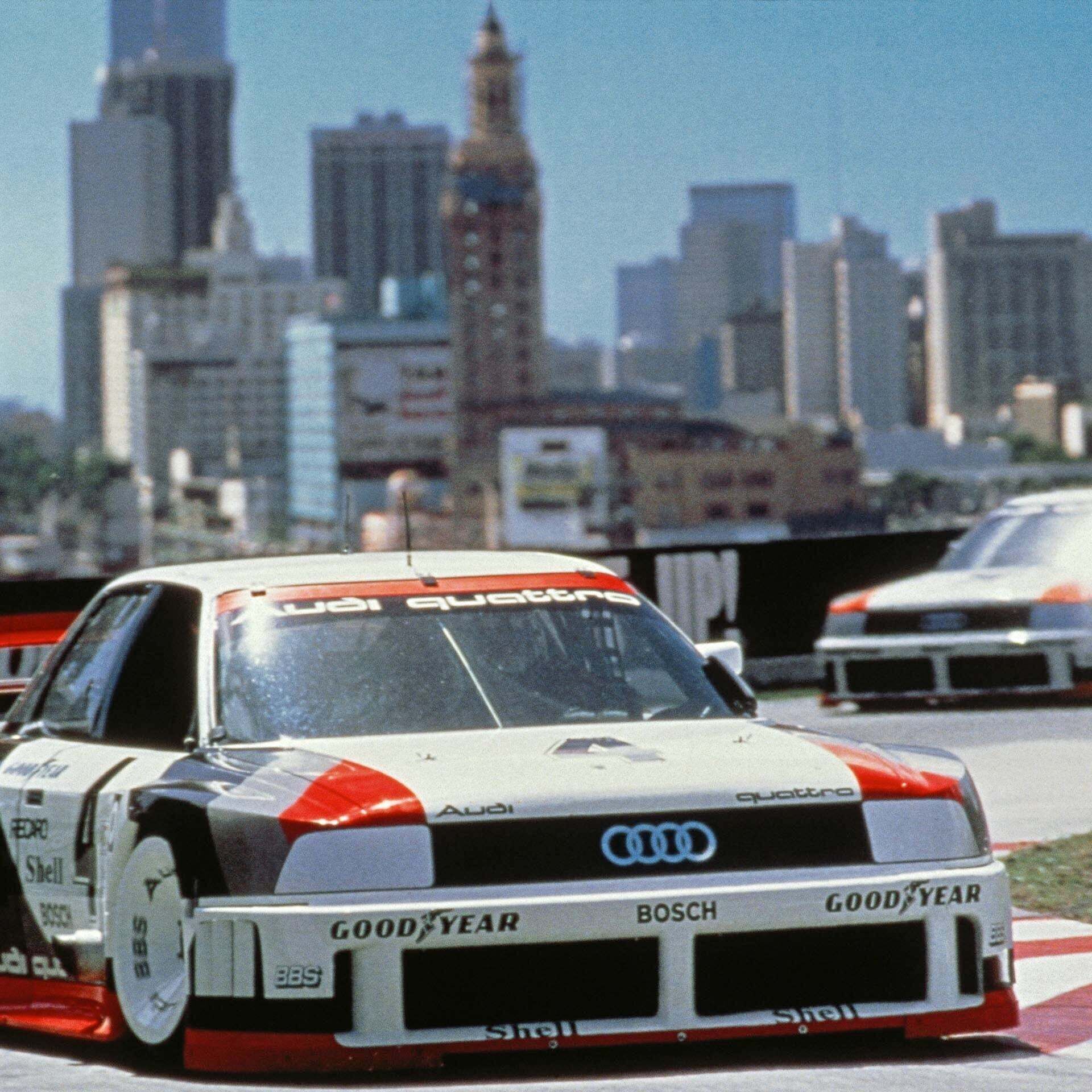 A picture showing two Audi 90 quattro IMSA GTO race cars on track in the USA in 1989.