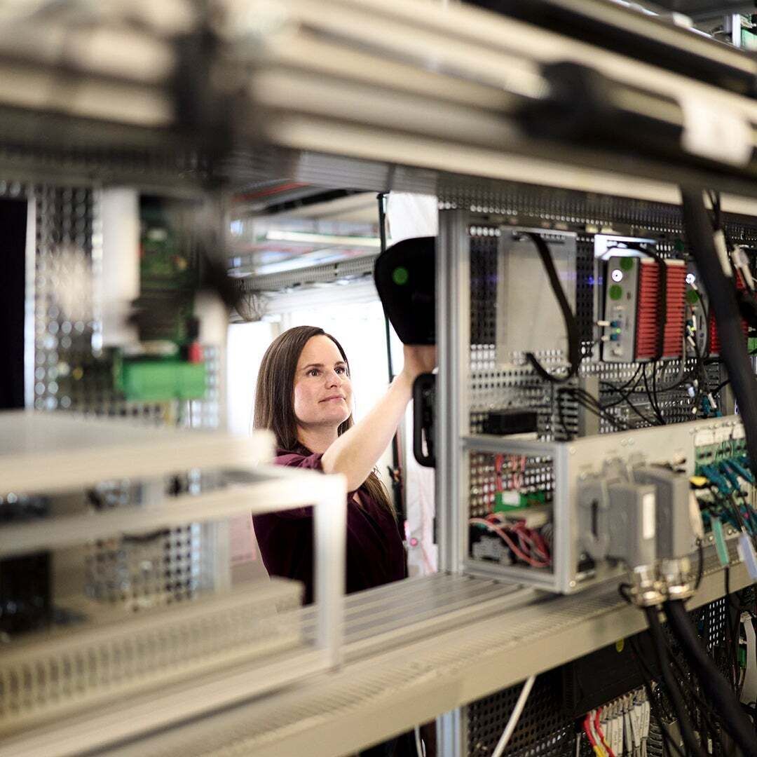 Melanie Schillinger steht an einem Gerät und hat ihre Hand darauf