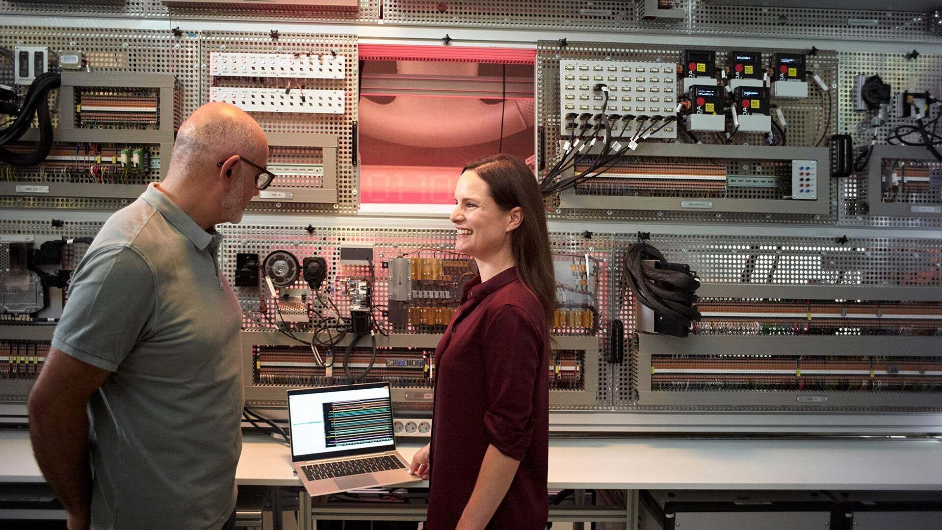 Melanie Schillinger bespricht sich mit einem Kollegen in einem Raum mit technischen Geräten