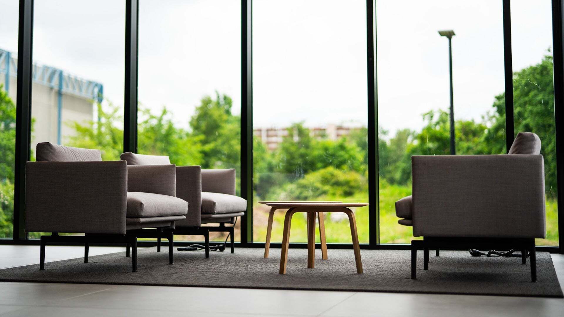 Seating in front of a window front with a view of the greenery