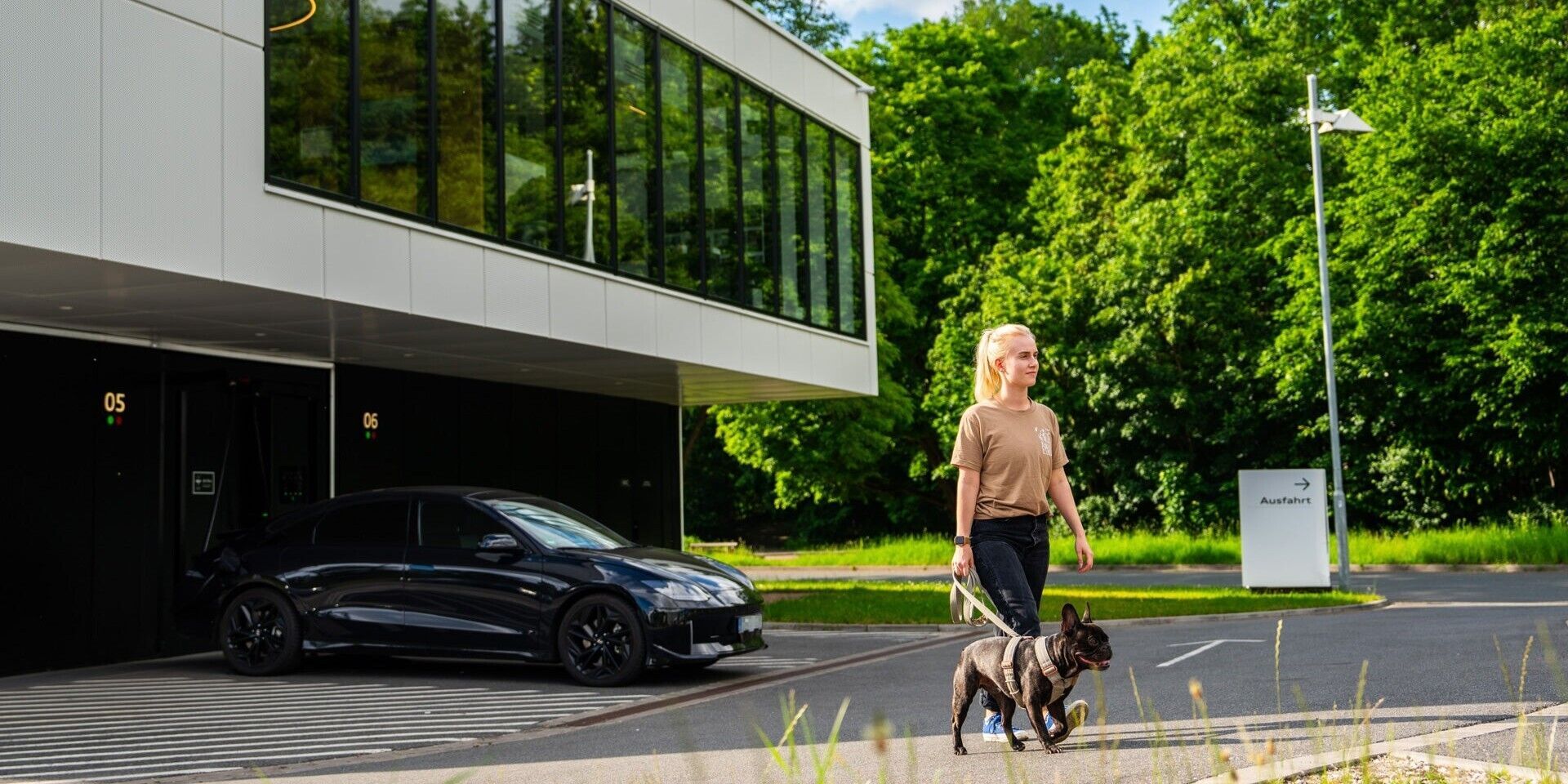 A woman walks away from the Charging hub with her dog on a lead