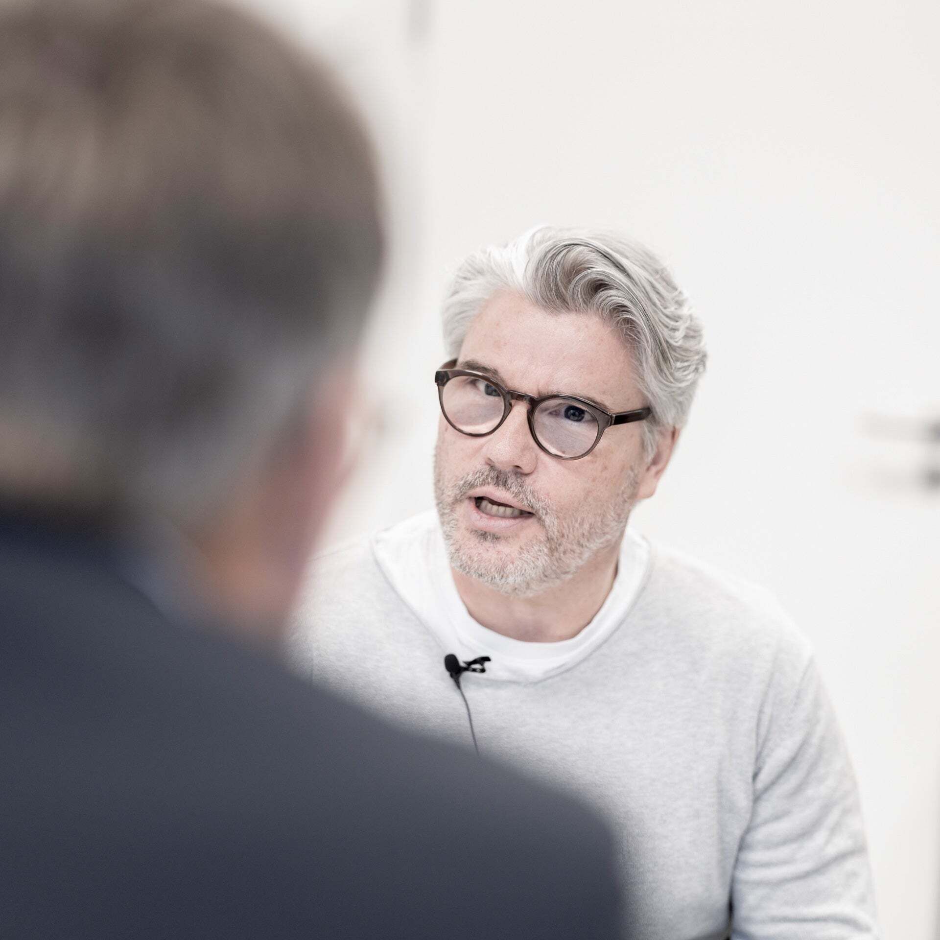 Heiko Schmidt talks to a person sitting with their back to the camera