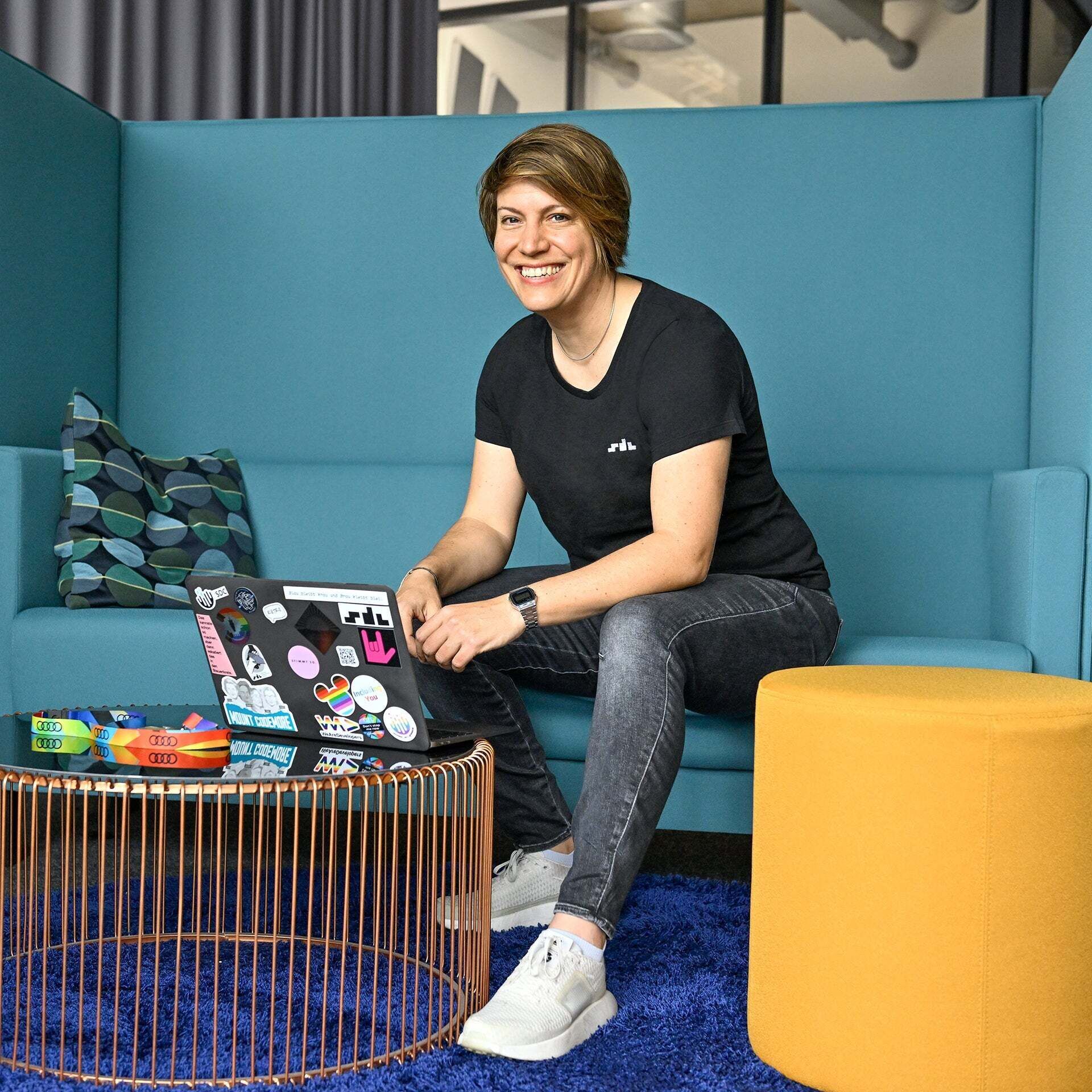 Dani Ambassador SDC, is sitting at her laptop and smiling at the camera