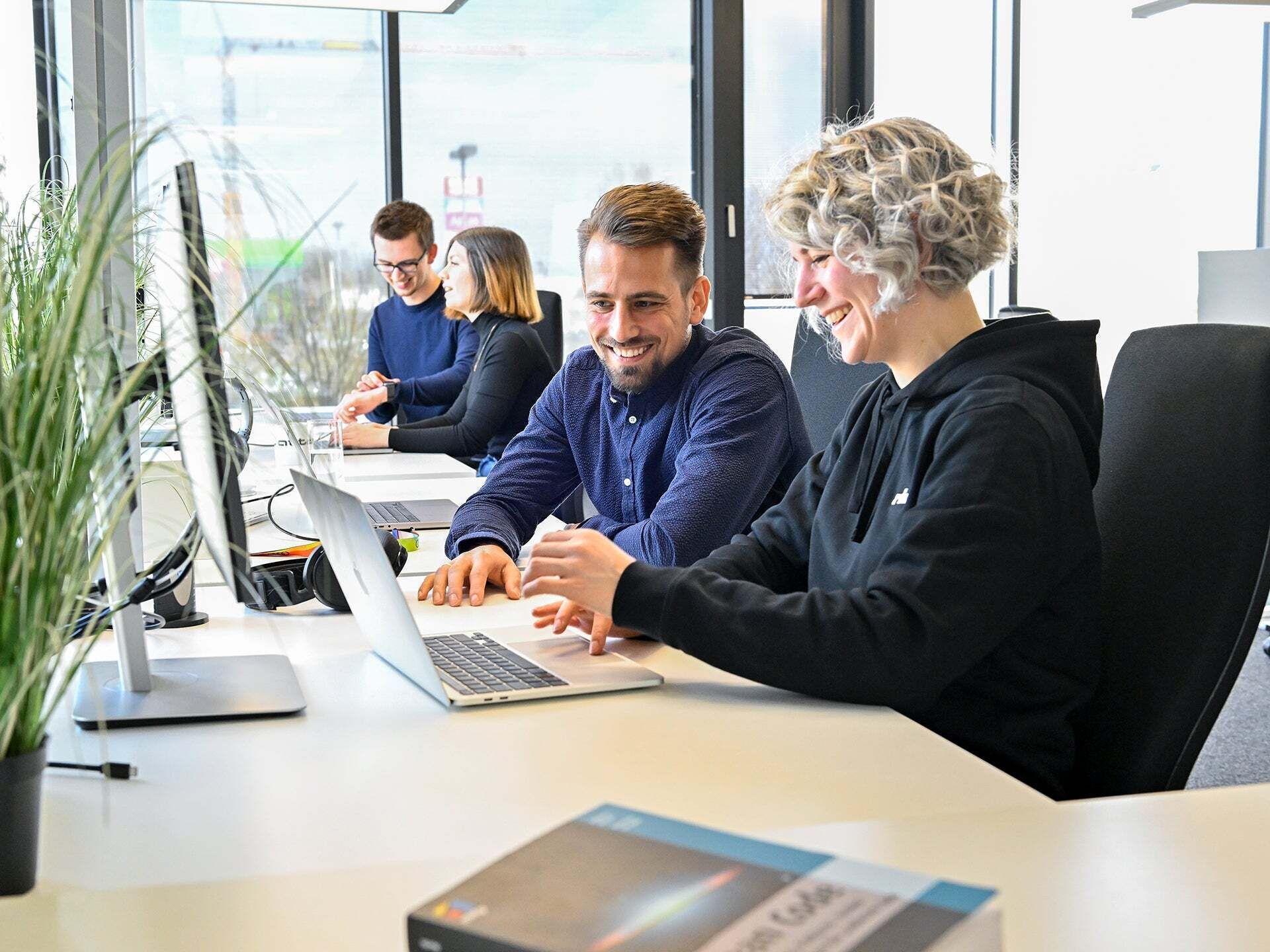 Markus, Product Manager SCD, looks at a laptop with a colleague