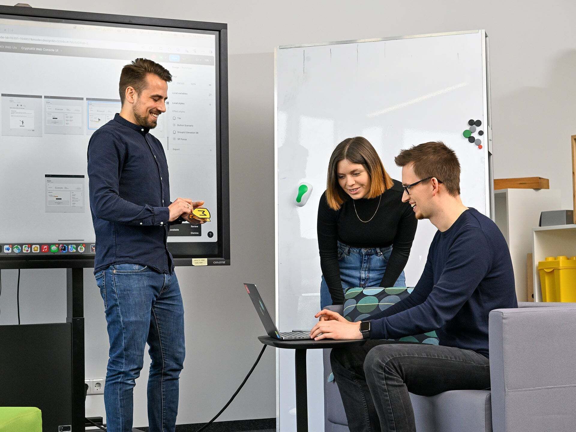 Lisa, Product Designer SDC, looks at a laptop with a colleague