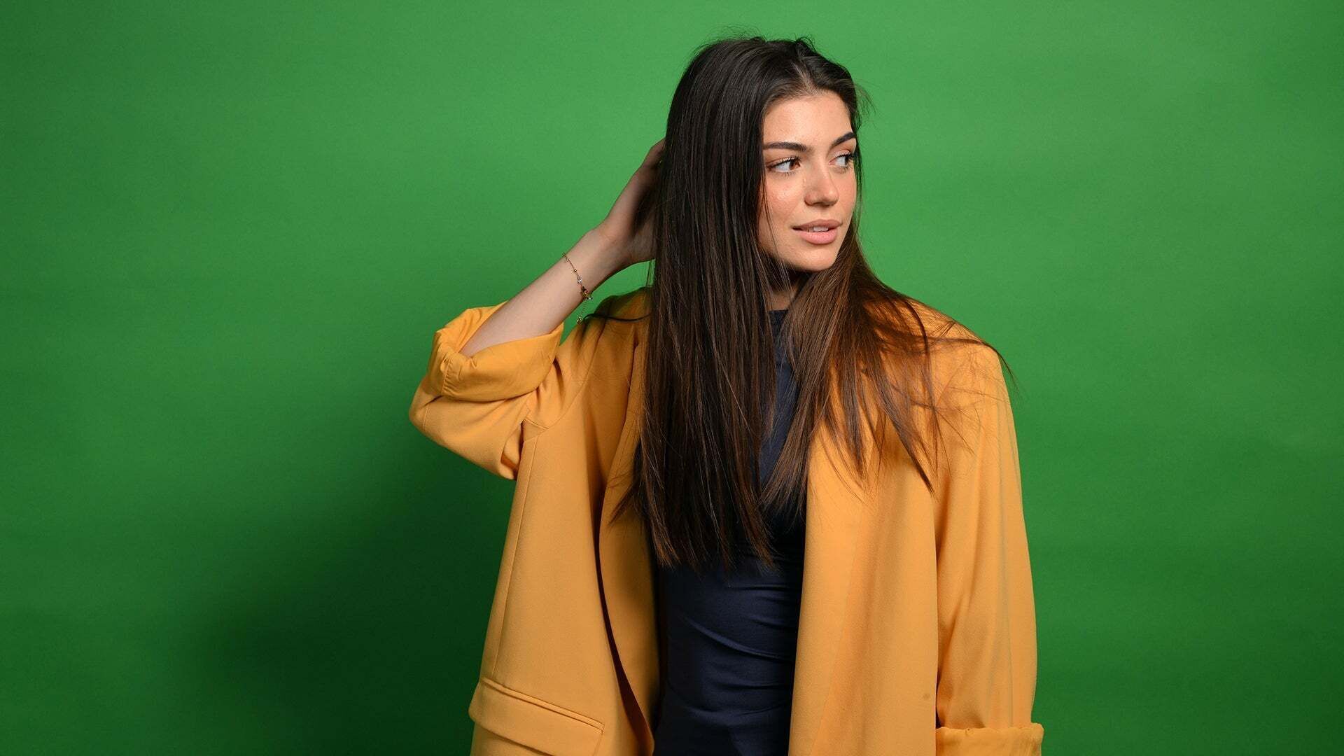 Emilia hat ihre rechte Hand in ihrem Haar und schaut nach links