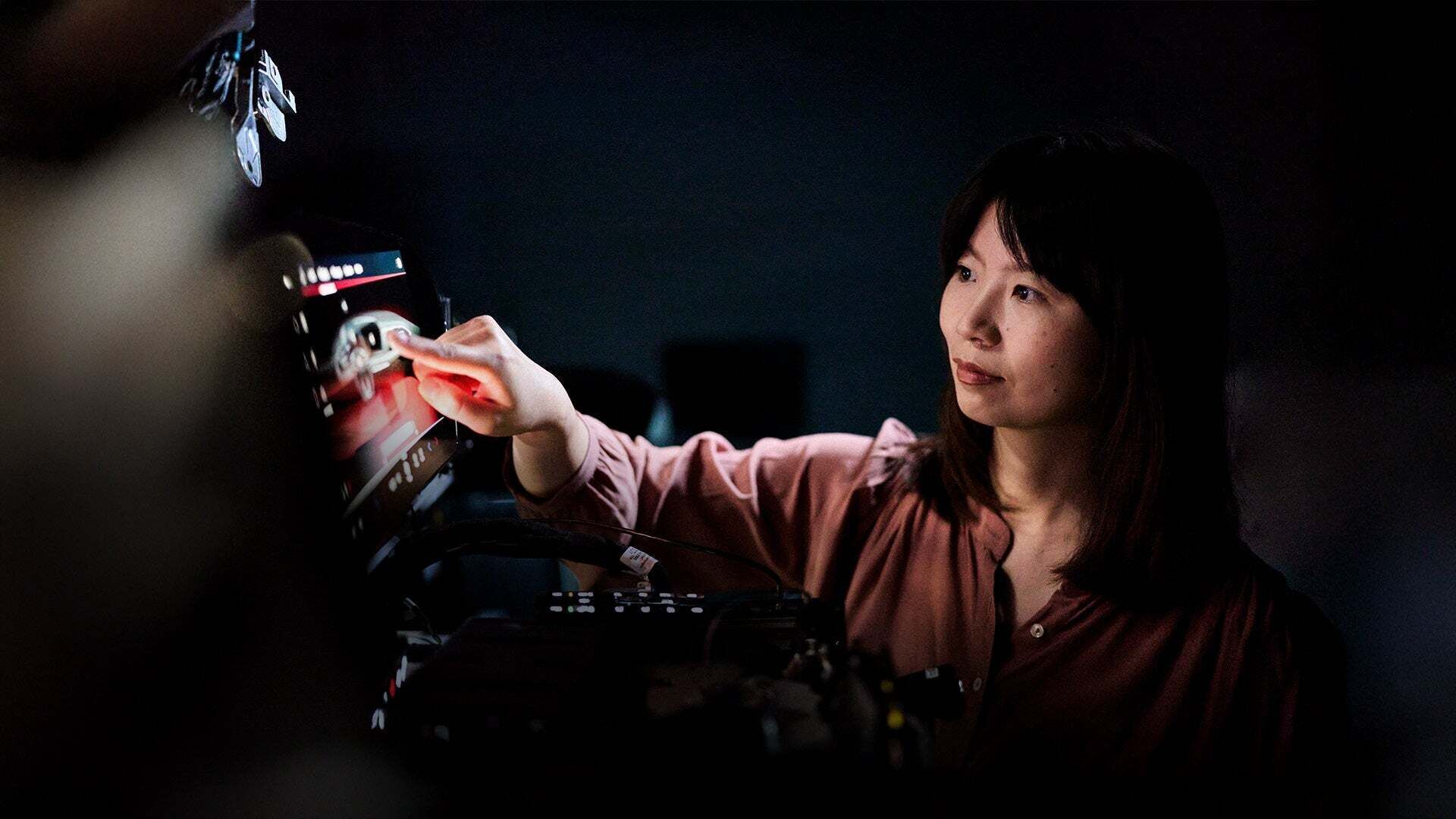Jiayi Long clicks her finger on the screen of a device
