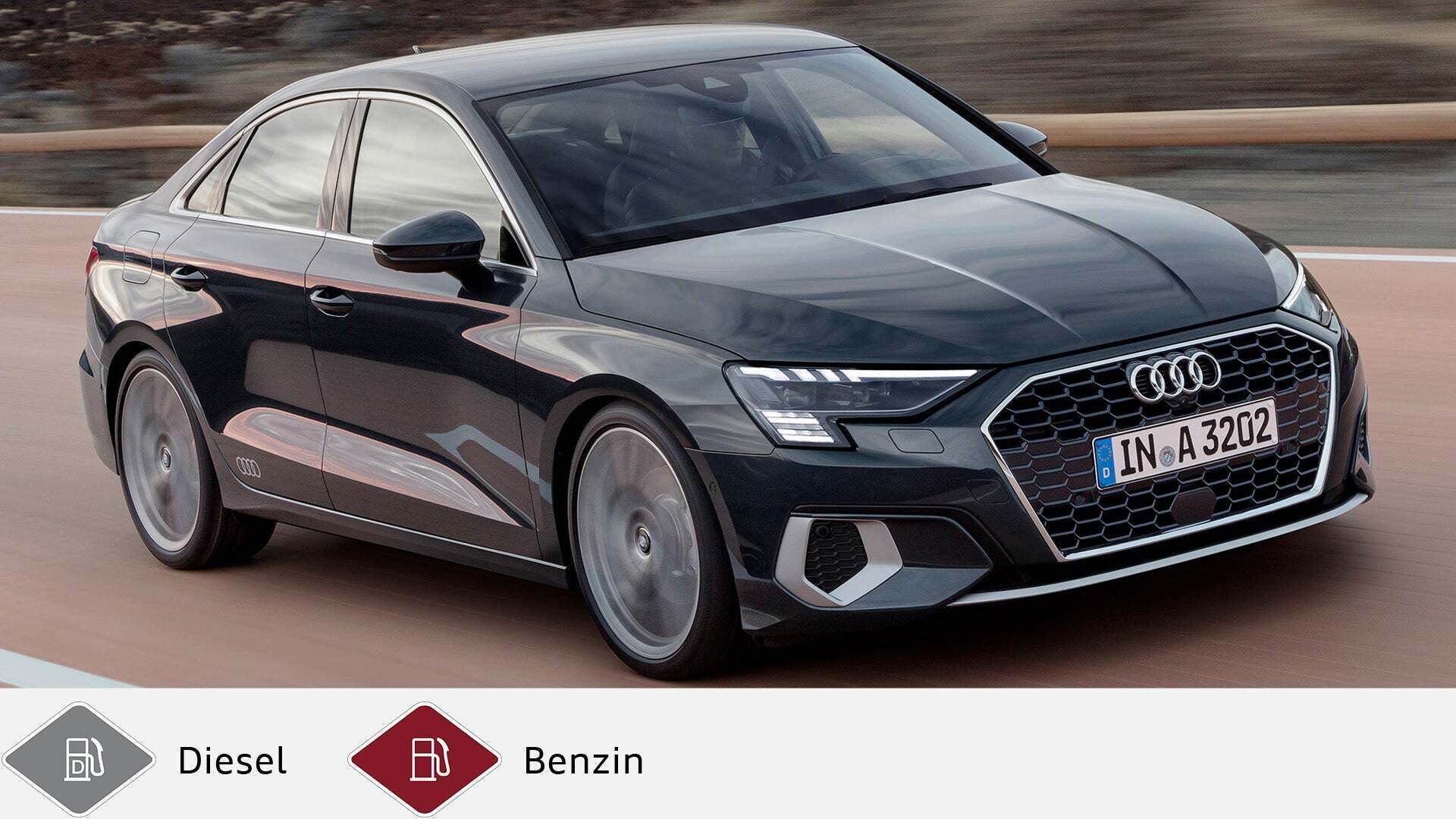 Dunkelgrauer Audi A3 Limousine fährt auf Landstraße, schräg frontal aufgenommen. Unten graues Dieselsymbol und rotes Benzinsymbol.
