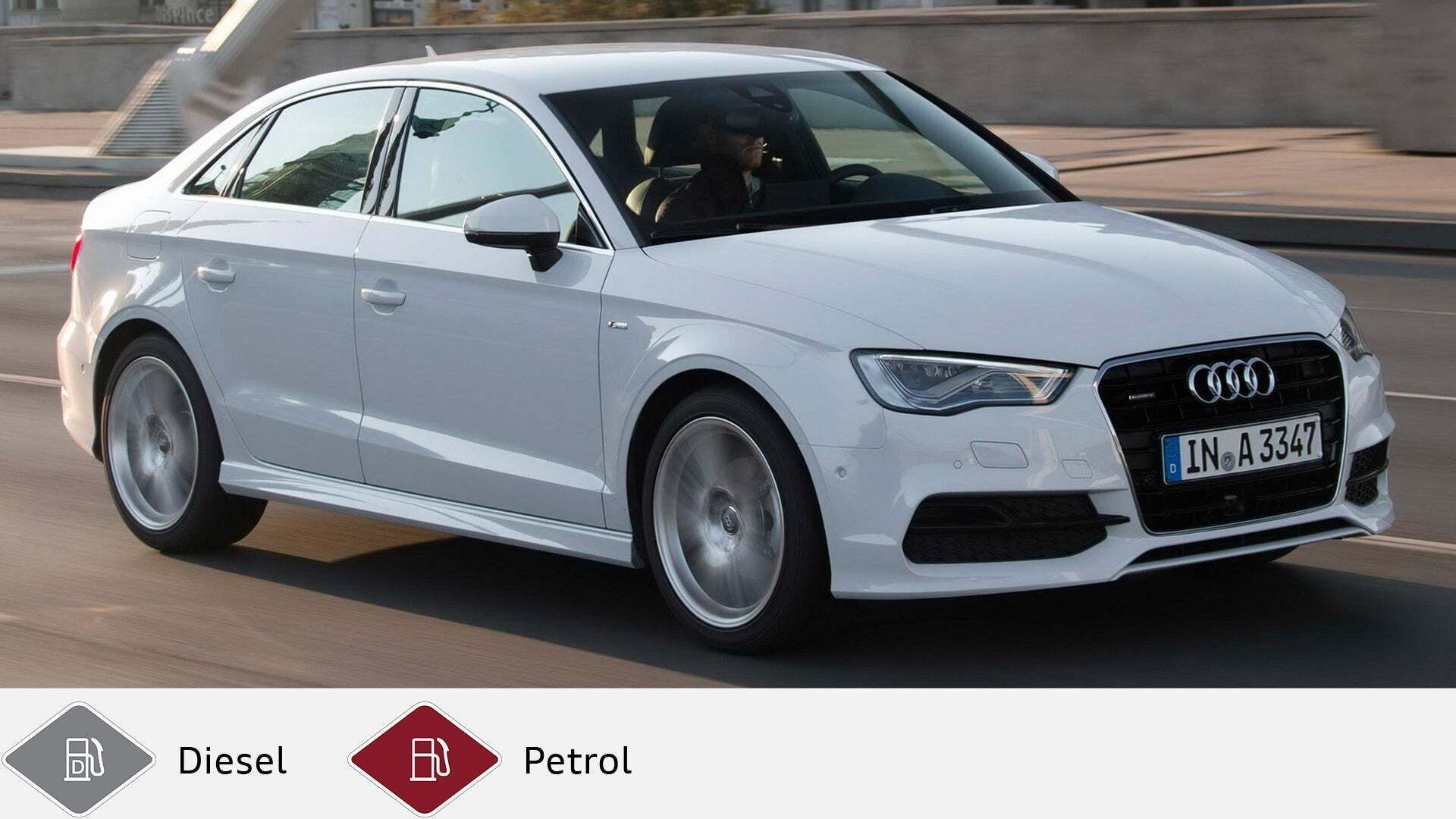 White Audi A3 sedan driving in a built-up area, photographed from the side. Gray diesel symbol and red petrol symbol at the bottom.
