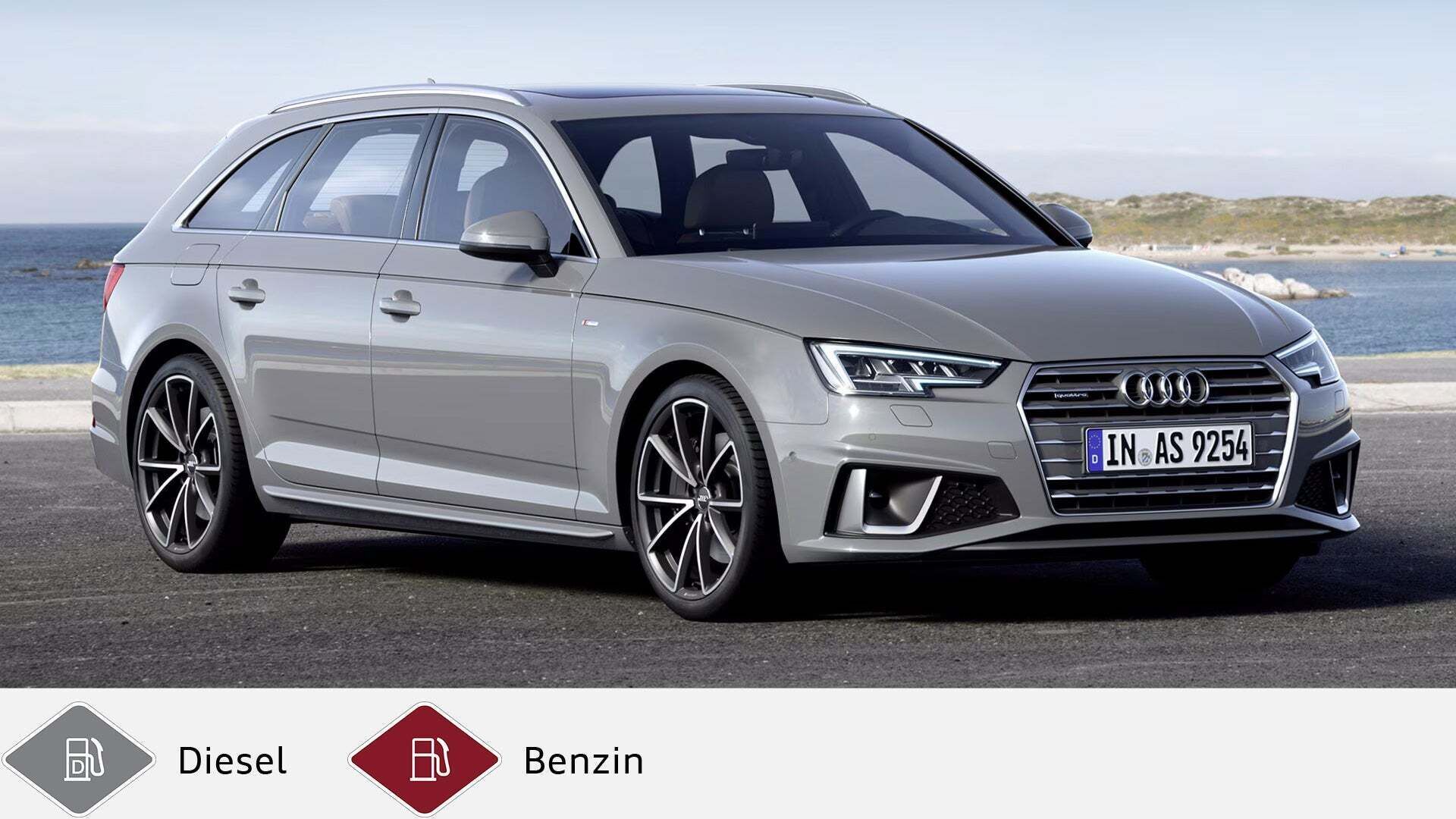 Grauer Audi A4 Avant steht an Küstenstraße, Blick von schräg vorne. Unten graues Dieselsymbol und rotes Benzinsymbol.
