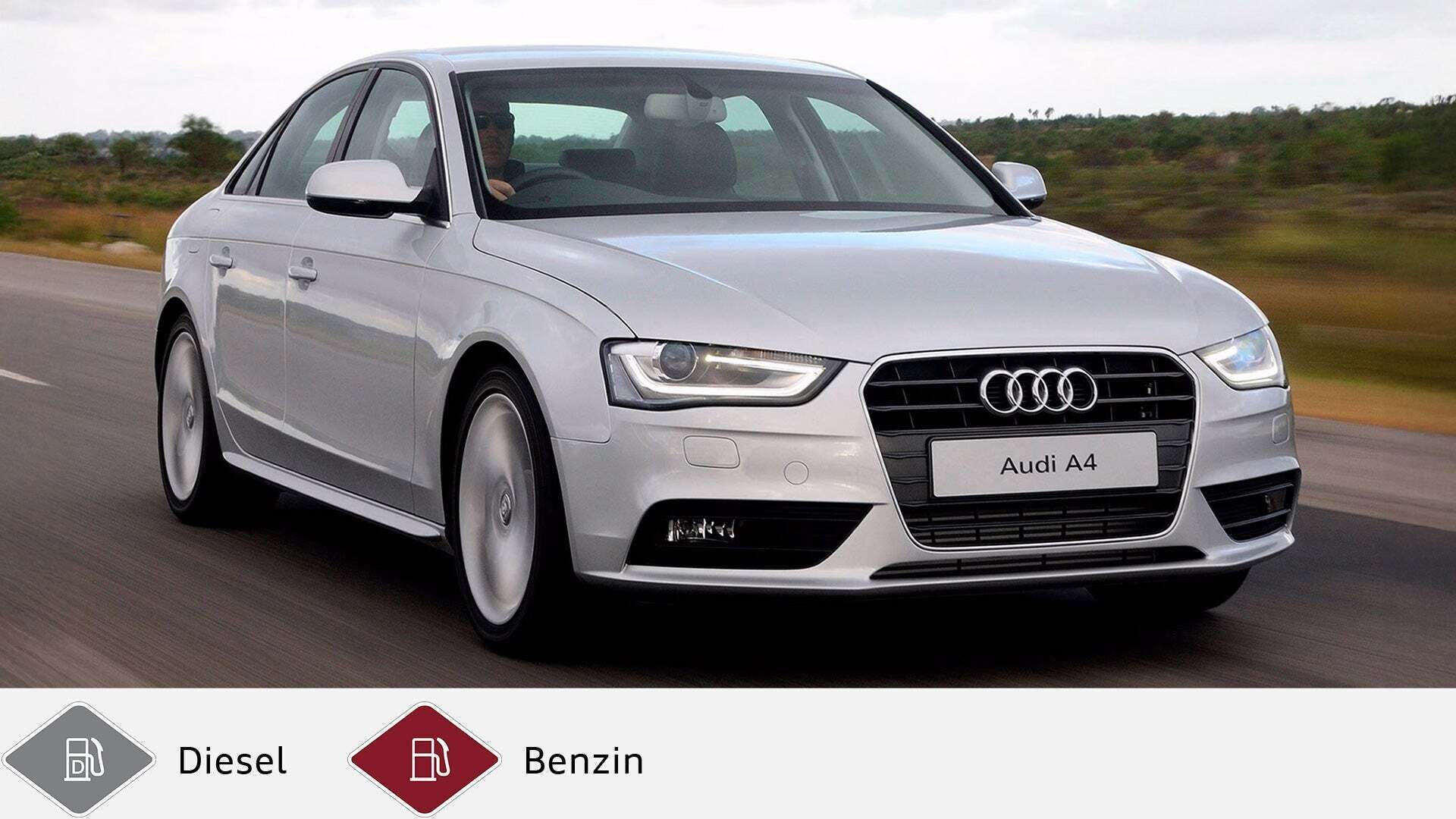 Silberner Audi A4 Limousine fährt auf Landstraße, Fahrer sichtbar hinterm Steuer. Unten graues Dieselsymbol und rotes Benzinsymbol.