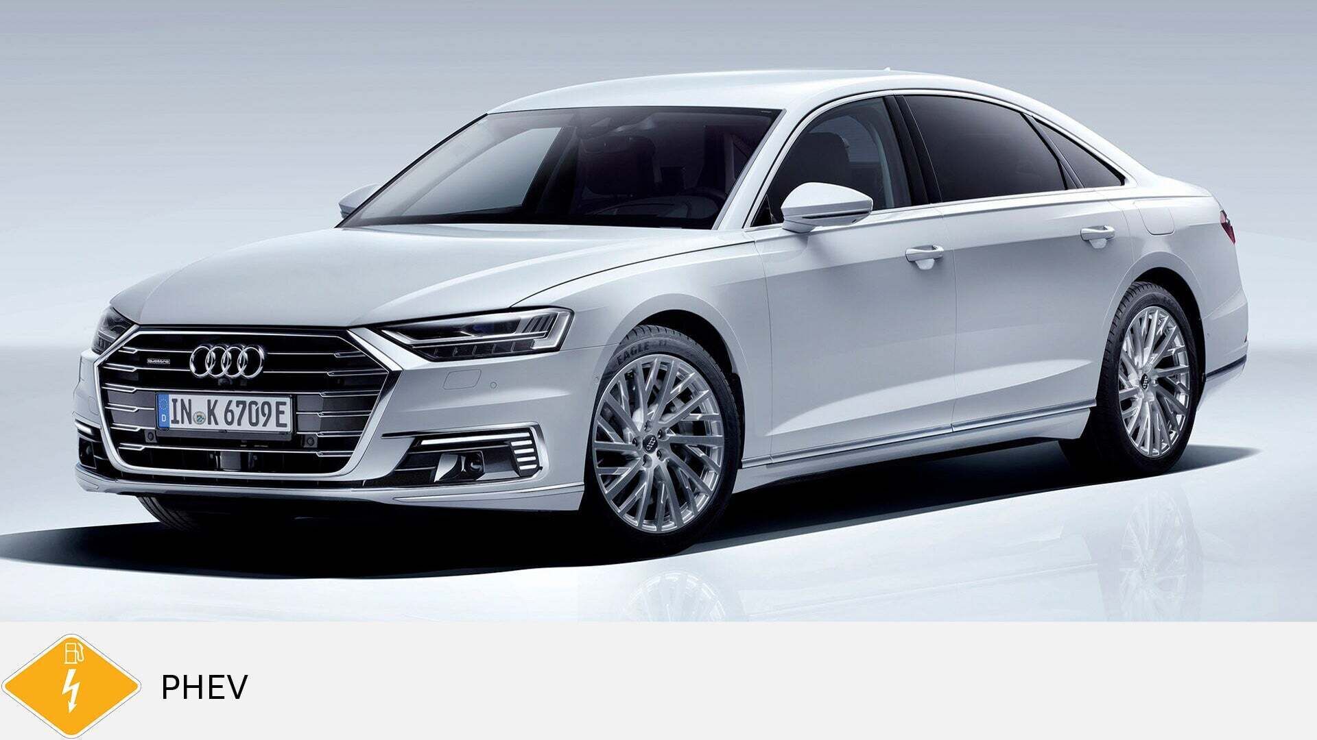 Weißer Audi A8 TFSI e steht in einem Studio mit hellem Hintergrund. Unten gelbes PHEV-Symbol mit Zapfsäule.