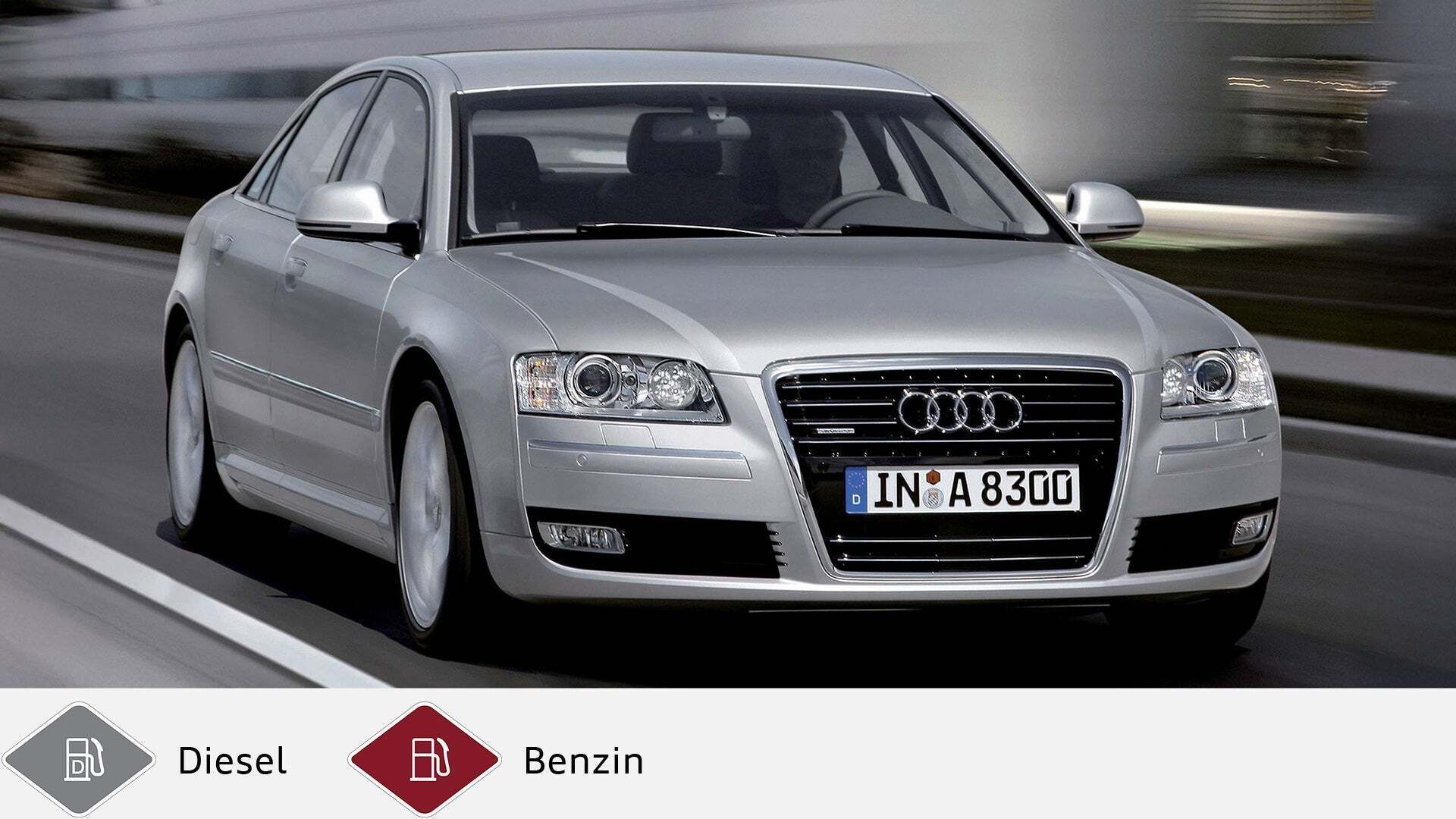 Silberner Audi A8 fährt auf einer Straße, Fahrer gut sichtbar, städtischer Hintergrund unscharf. Unten graues Dieselsymbol und rotes Benzinsymbol.
