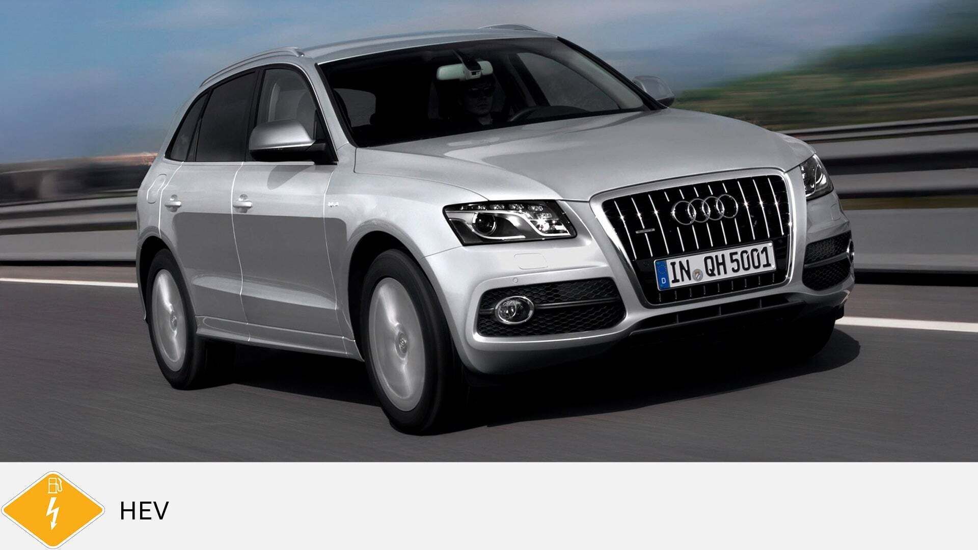 Silberner Audi Q5 hybrid fährt auf Autobahn. Unten gelbes PHEV-Symbol mit Zapfsäule und Blitz.