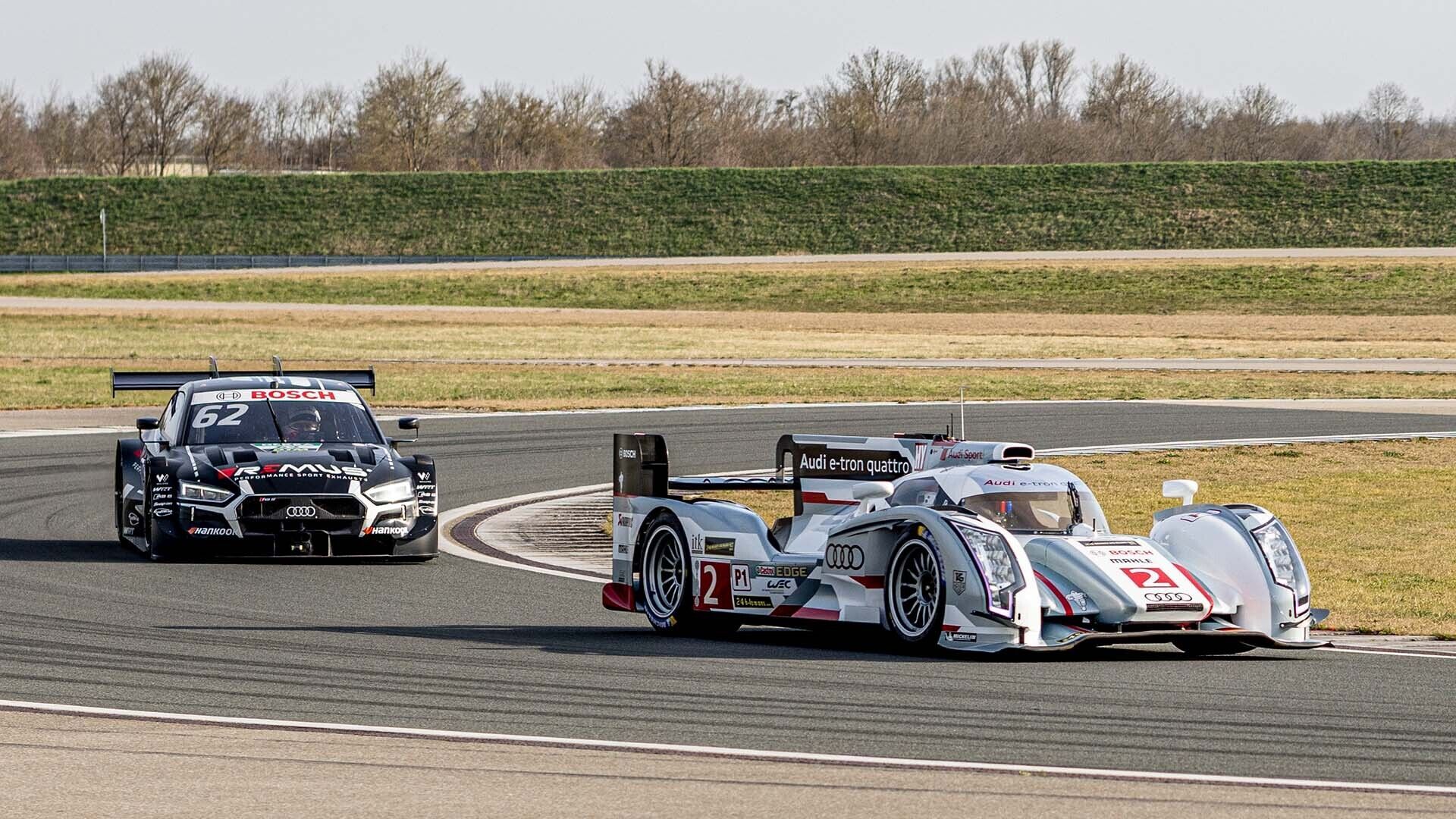 Das Foto zeigt zwei Rennwagen der Audi Sport racing legends, die auf der Rennstrecke in Neuburg vorgeführt werden.