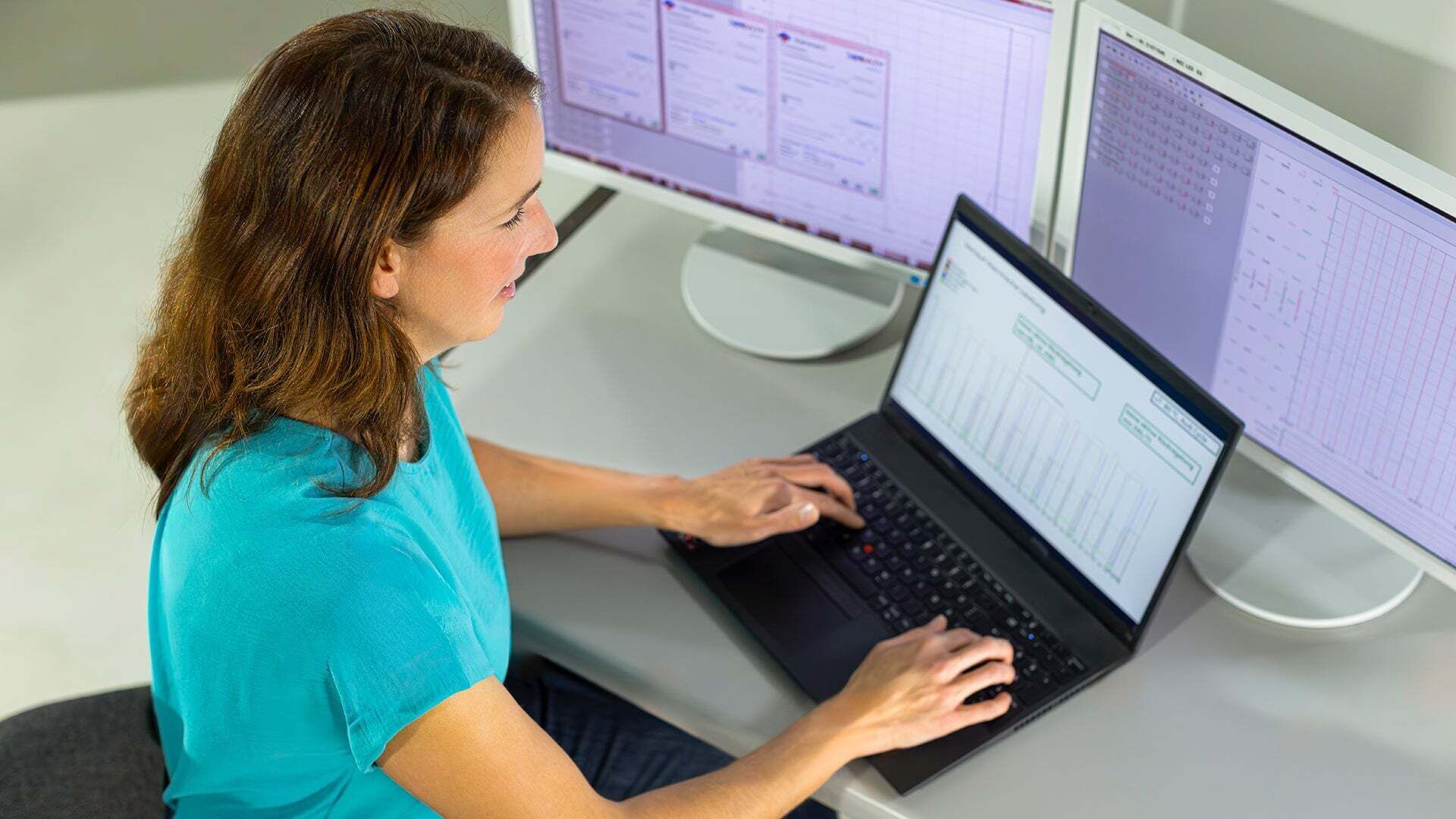 Meike Gallant sitzt am Laptop und hat noch 2 extra Bildschirme vor sich