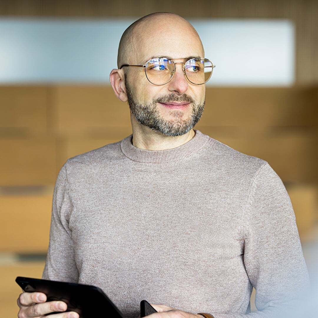 Mario de Felice schaut rechts an die Kamera vorbei und trägt eine Brille