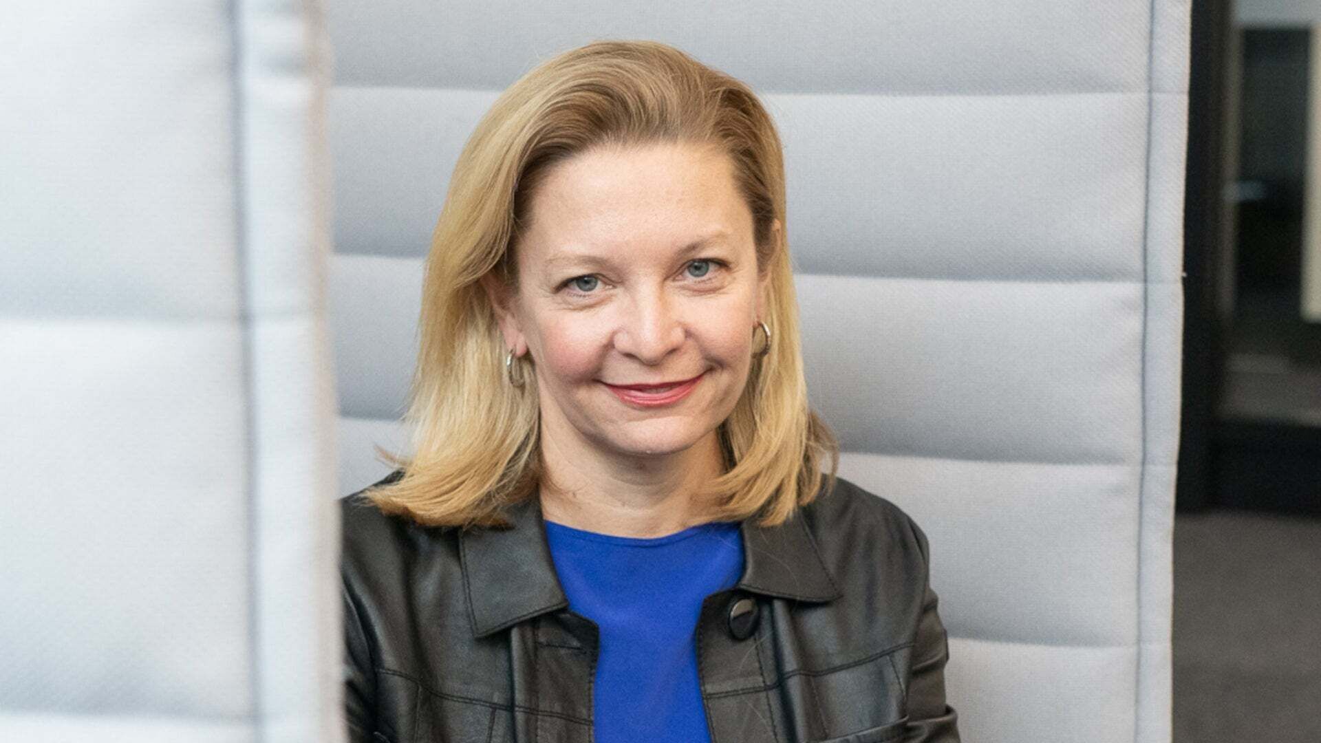 Portraitbild von Elke Neidlein auf einer weißen Couch