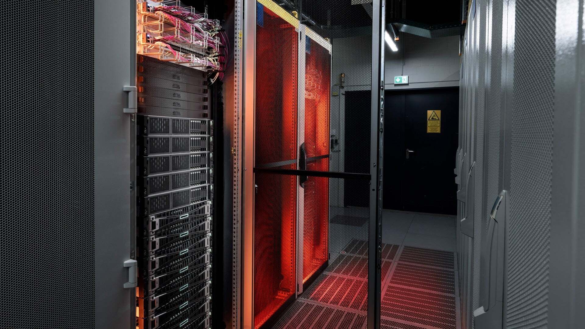 Orange beleuchtete Edge Cloud Server in Metallschränken mit Lochgittertüren.