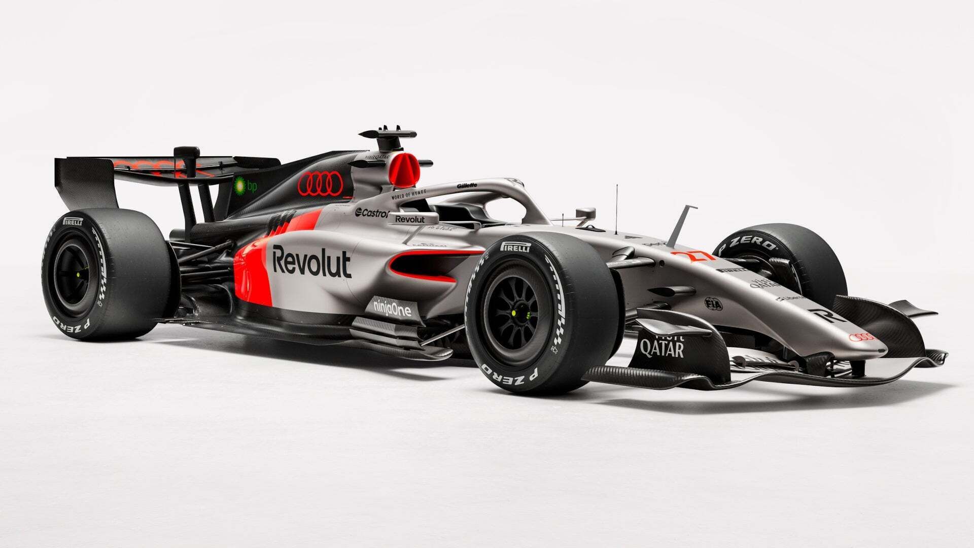 The Audi R26 Formula 1 race car with black, grey, and red racing livery is positioned in a dark studio, lit from the side, with visible sponsor logos.