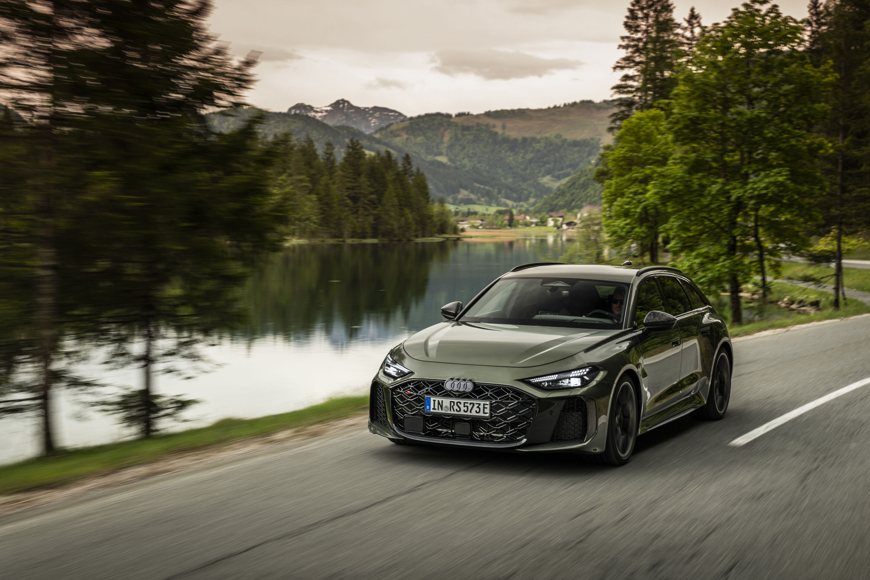 Audi RS 5 Avant - Audi RS 5 Avant in Bedfordgrün, Outdoor-Fahraufnahme, Exterieur, Frontansicht auf Straße entlang eines Sees.