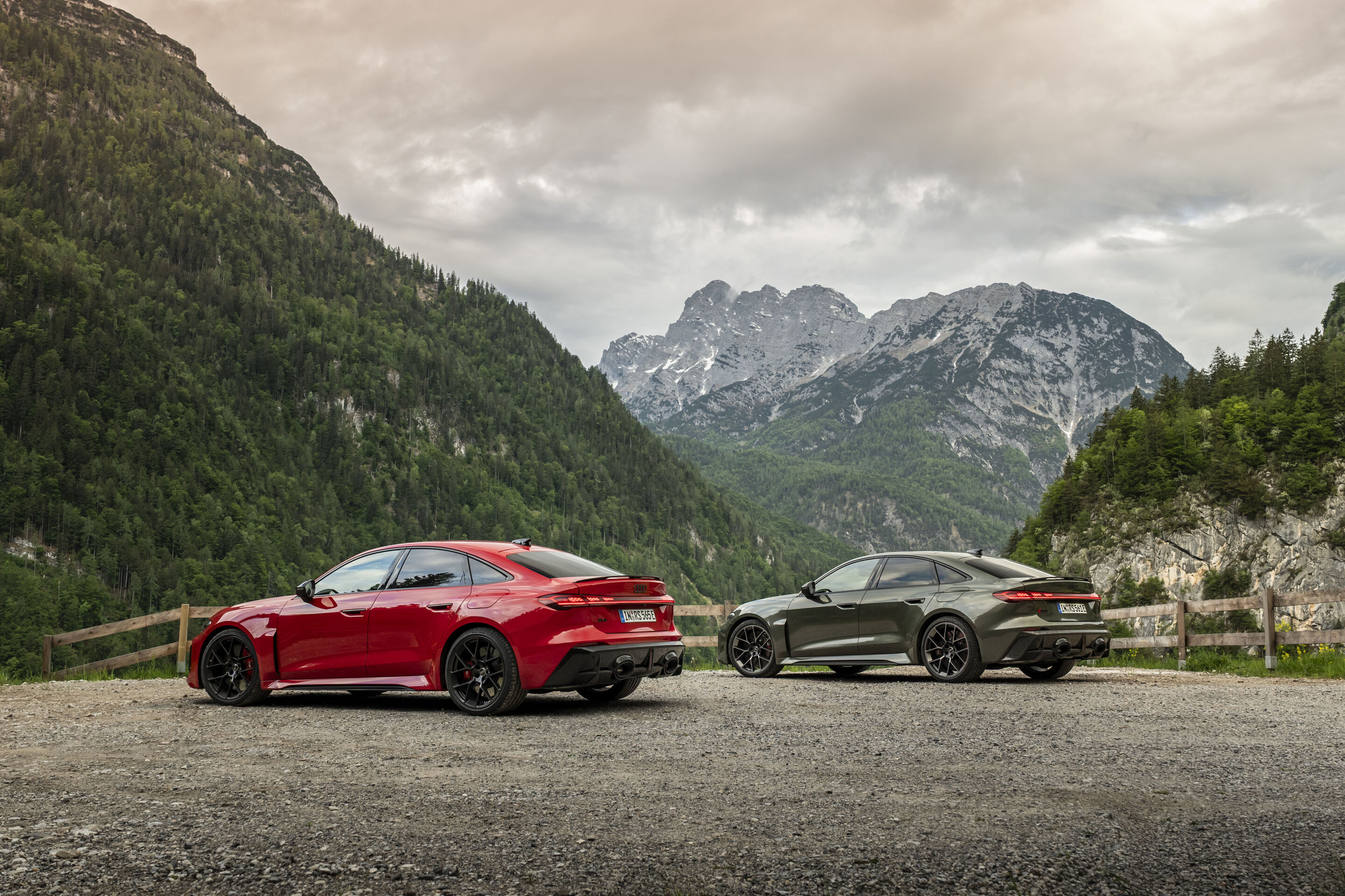 Audi RS 5 Limousine - Von links im Bild: Audi RS 5 Limousine in Progressivrot und Audi RS 5 Limousine in Bedfordgrün, Outdoor-Standaufnahme, Exterieur, vor alpiner Bergkulisse.