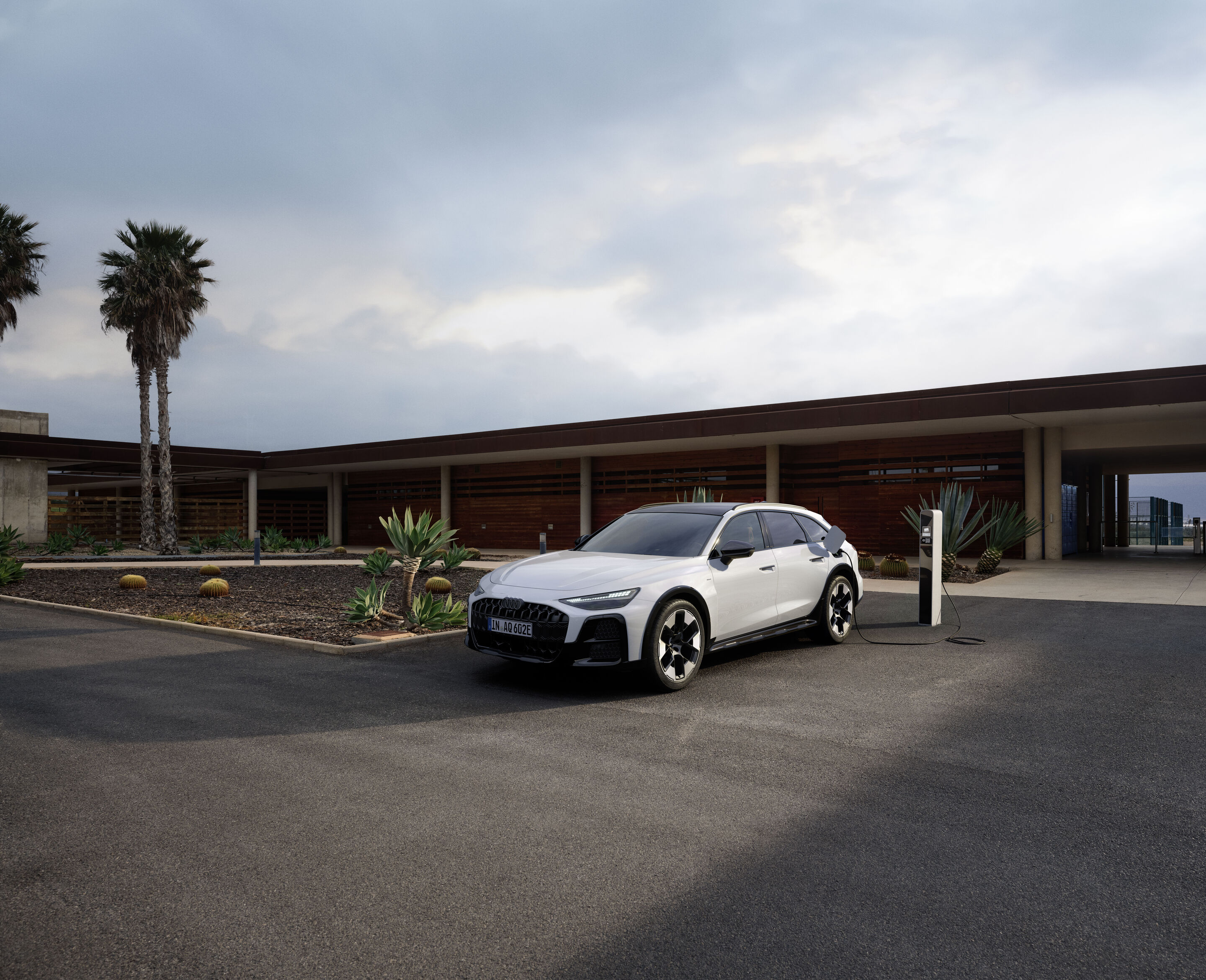 Audi A6 allroad e-hybrid quattro - Standaufnahme: Audi A6 allroad e-hybrid (gletscherweiß) an einer Ladesäule.
