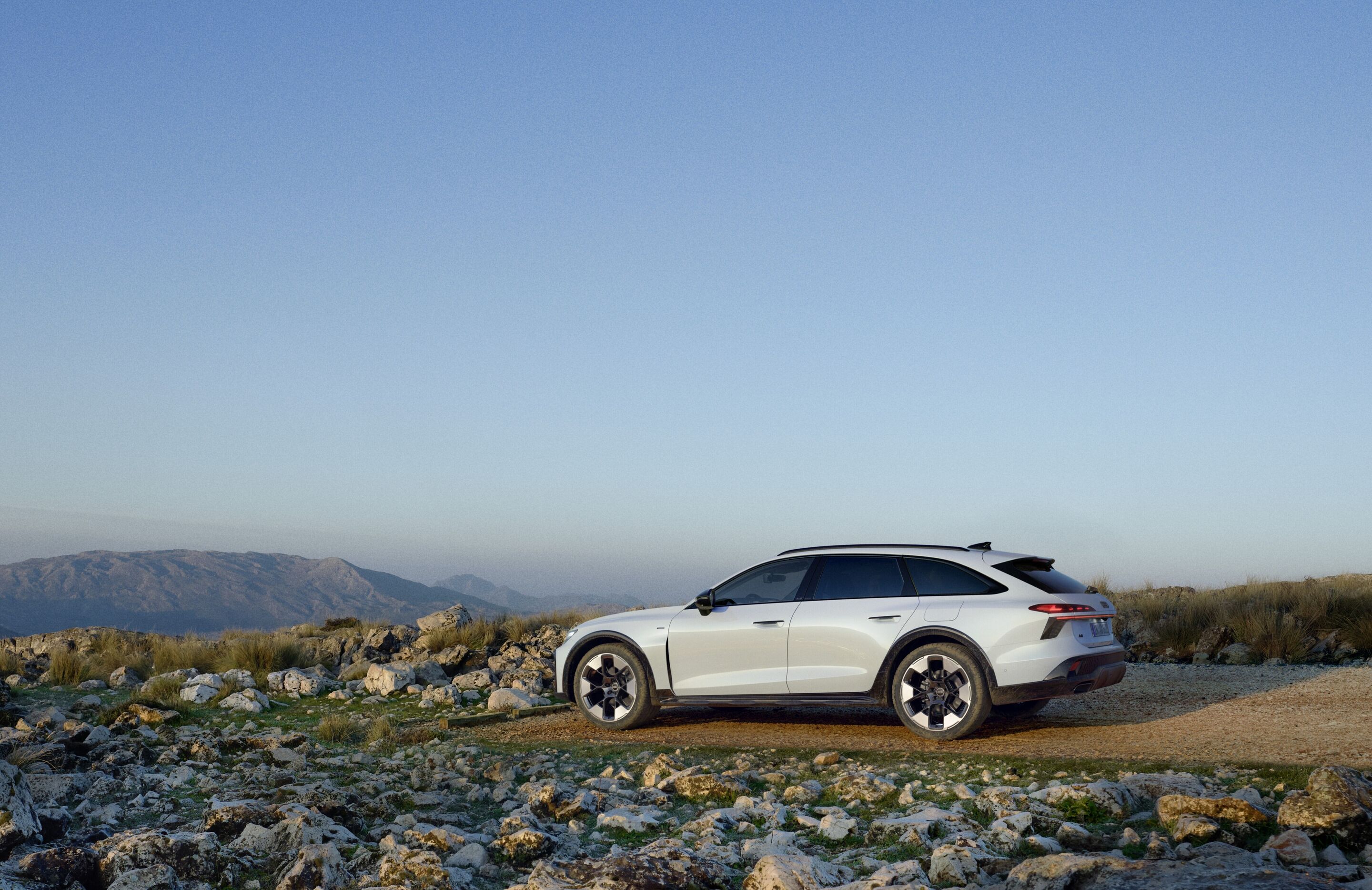 Audi A6 allroad e-hybrid quattro - Standaufnahme: Audi A6 allroad e-hybrid (gletschweiß) auf steinigem Untergrund mit Blick in die Berge.