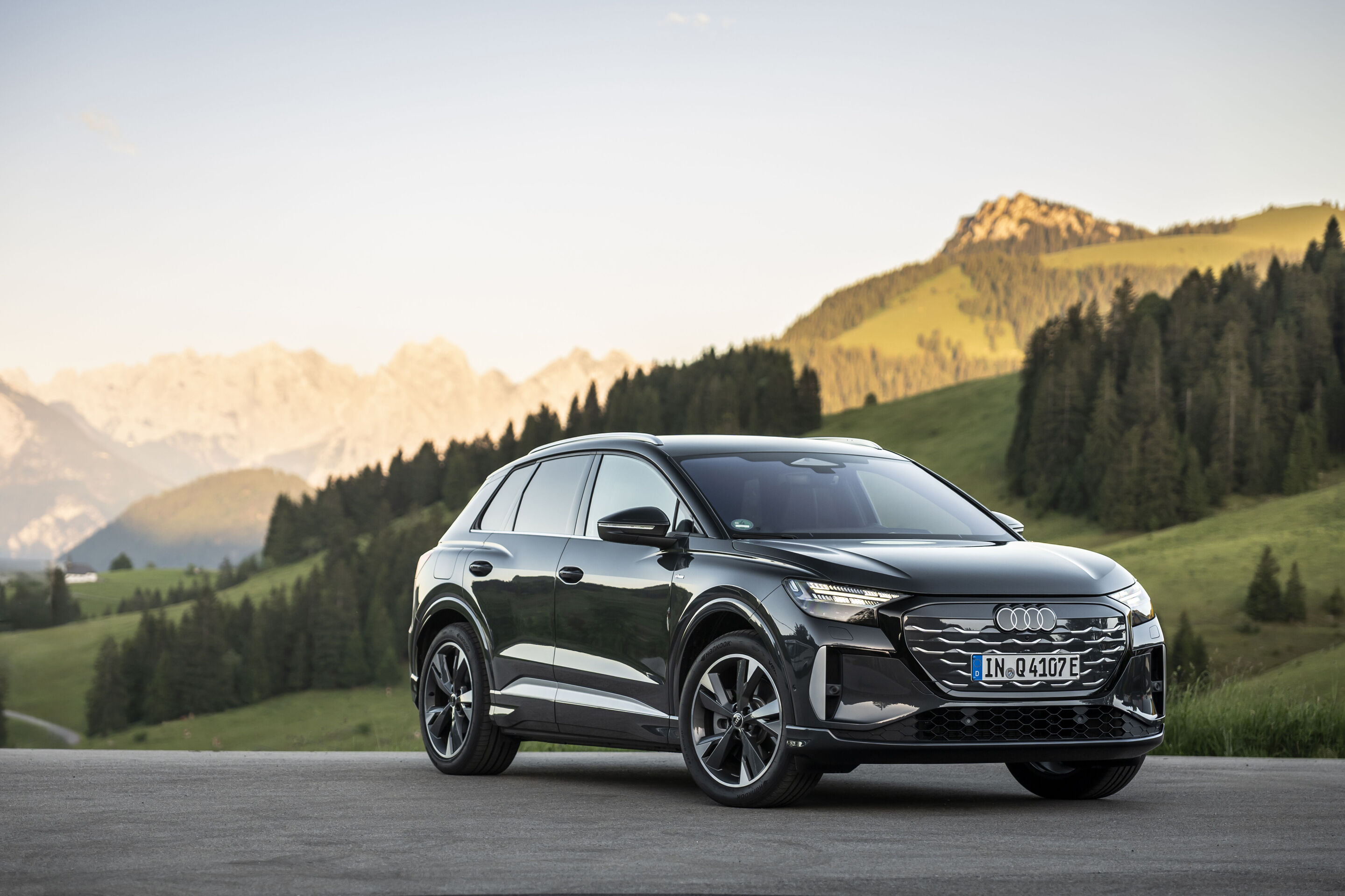 Ein Auto für jeden Moment: Unterwegs im Audi Q4 e-tron - Audi Q4 SUV e-tron in Tamboragrau, Outdoor-Standaufnahme, Exterieur, Dreiviertelfrontansicht vor alpiner Landschaft.