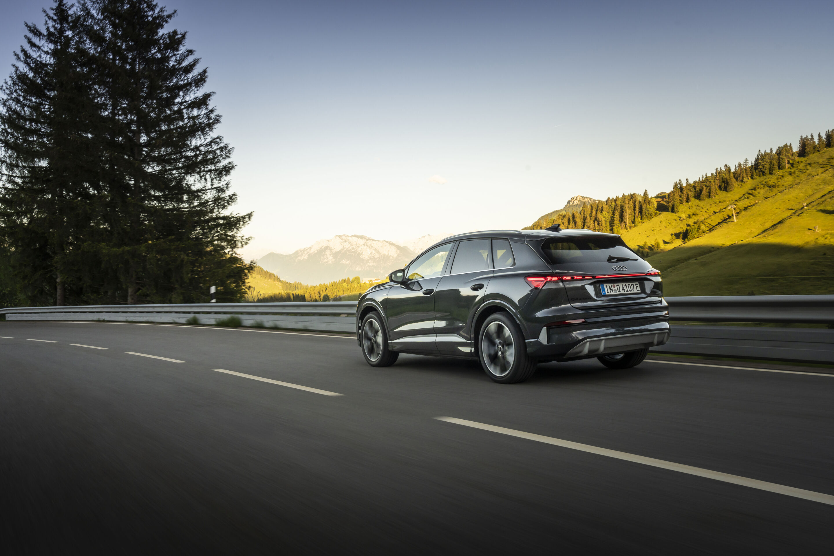 Ein Auto für jeden Moment: Unterwegs im Audi Q4 e-tron - Audi SUV Q4 e-tron in Tamboragrau, Outdoor-Fahraufnahme, Exterieur, Dreiviertelheckansicht in alpiner Landschaft.