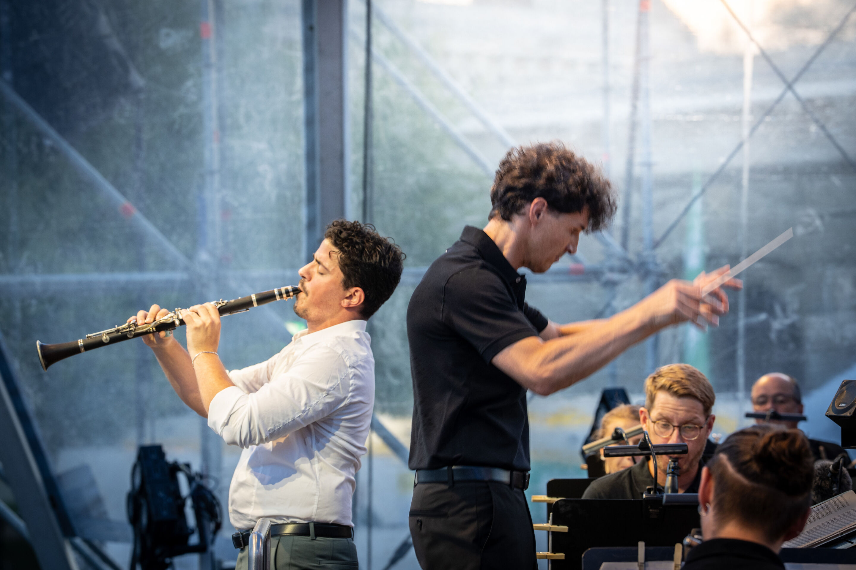 Die Audi Bläserphilharmonie beim Eröffnungskonzert/Klassik Open Air im Klenzepark - Rücken an Rücken auf der Bühne des Klassik Open Airs im Klenzepark: Klarinettensolist Elad Navon (links) und Dirigent Mathias Wehr (rechts) beim Eröffnungskonzert der...