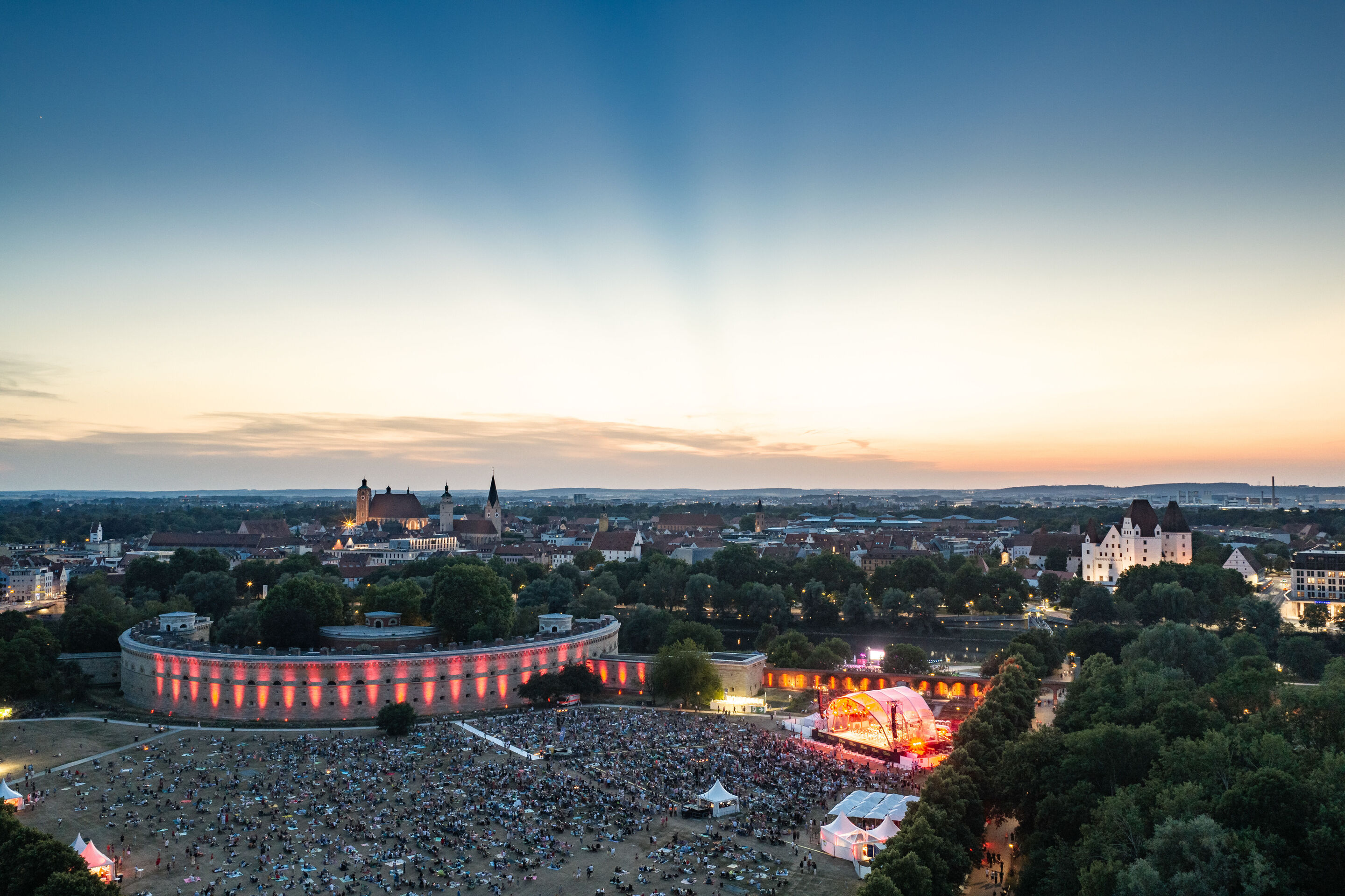 Die Audi Bläserphilharmonie beim Eröffnungskonzert/Klassik Open Air im Klenzepark - Der Klenzepark aus der Vogelperspektive: Rund 6.000 Besucherinnen und Besucher versammeln sich vor der großen Open-Air-Bühne zum Eröffnungskonzert der Audi Sommerkonzerte...