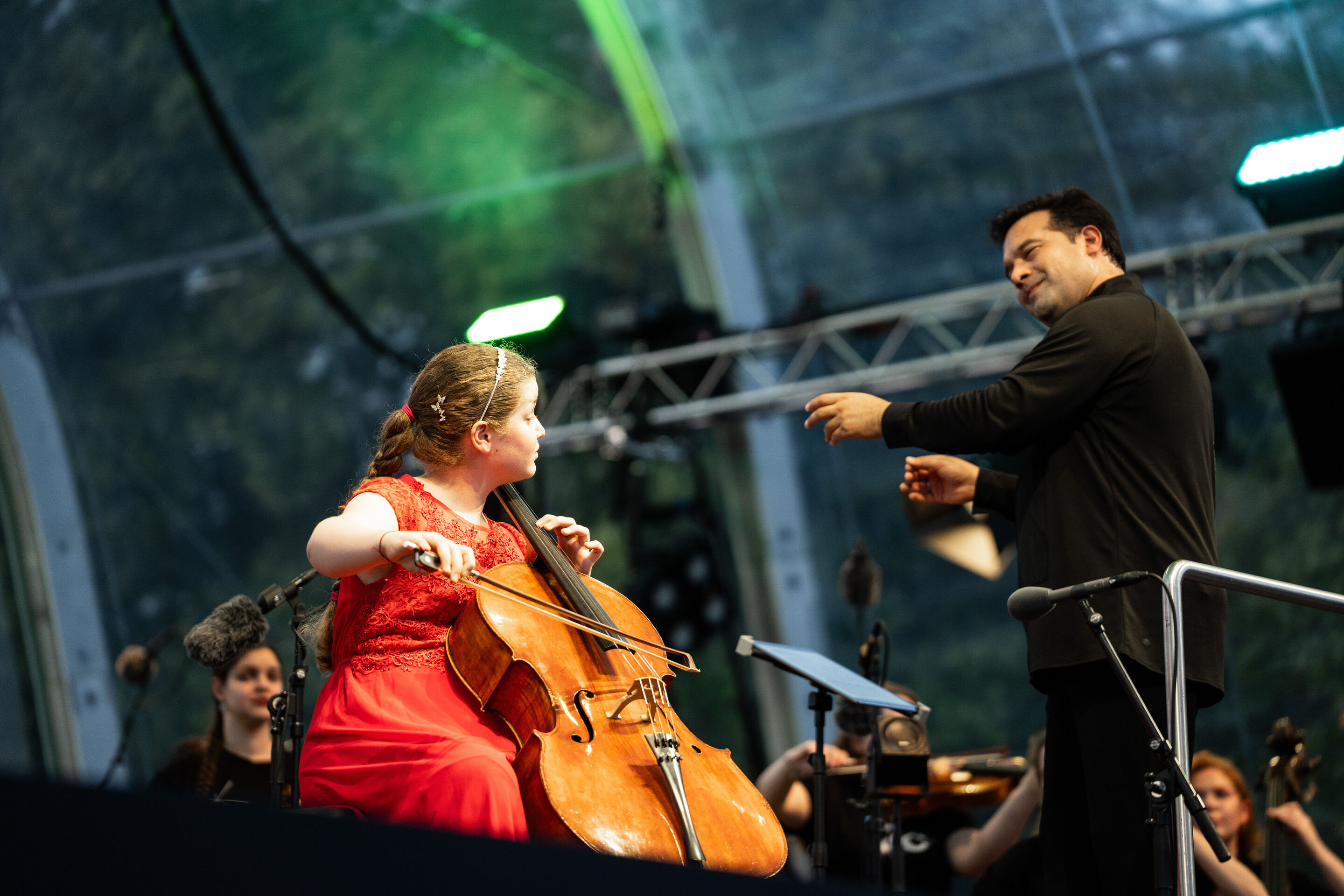 Baltic Sea Philharmonic beim Klassik Open Air im Klenzepark - Charlotte Melkonian am Violoncello und Dirigent Robert Treviño beim Klassik Open-Air im Klenzepark 2026 während eines Auftritts mit dem Baltic Sea Philharmonic.