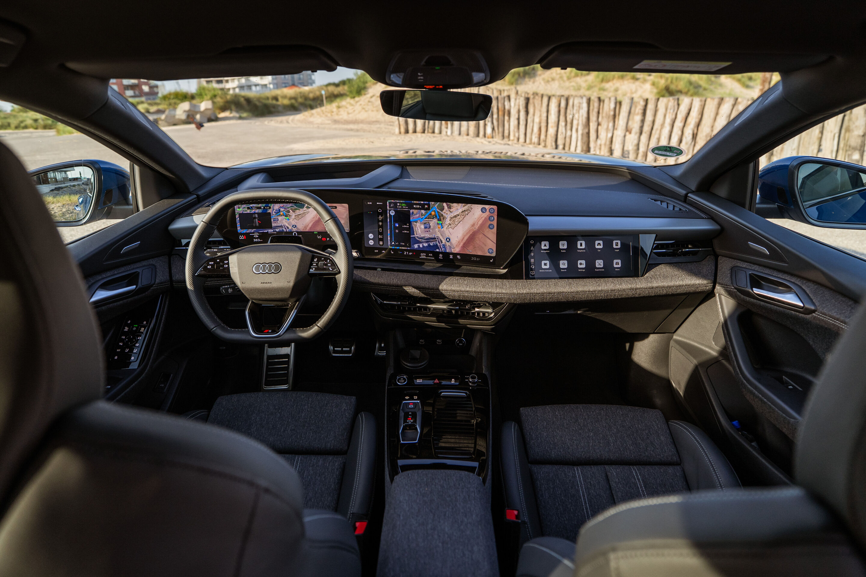 Audi Q6 e-tron Lifecycle Experience - Innenraum des Audi Q6 e-tron mit Darstellung der Erlebniswelt: Blick auf Vordersitze, digitales Cockpit und durchgehendes Display